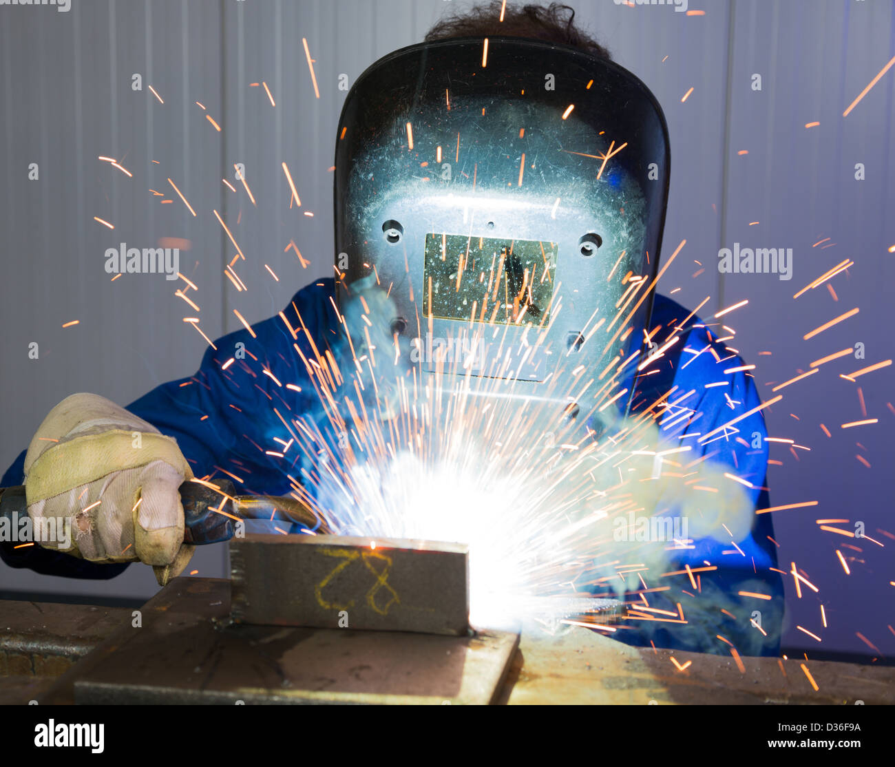 Man with welding helmet welding steel Stock Photo