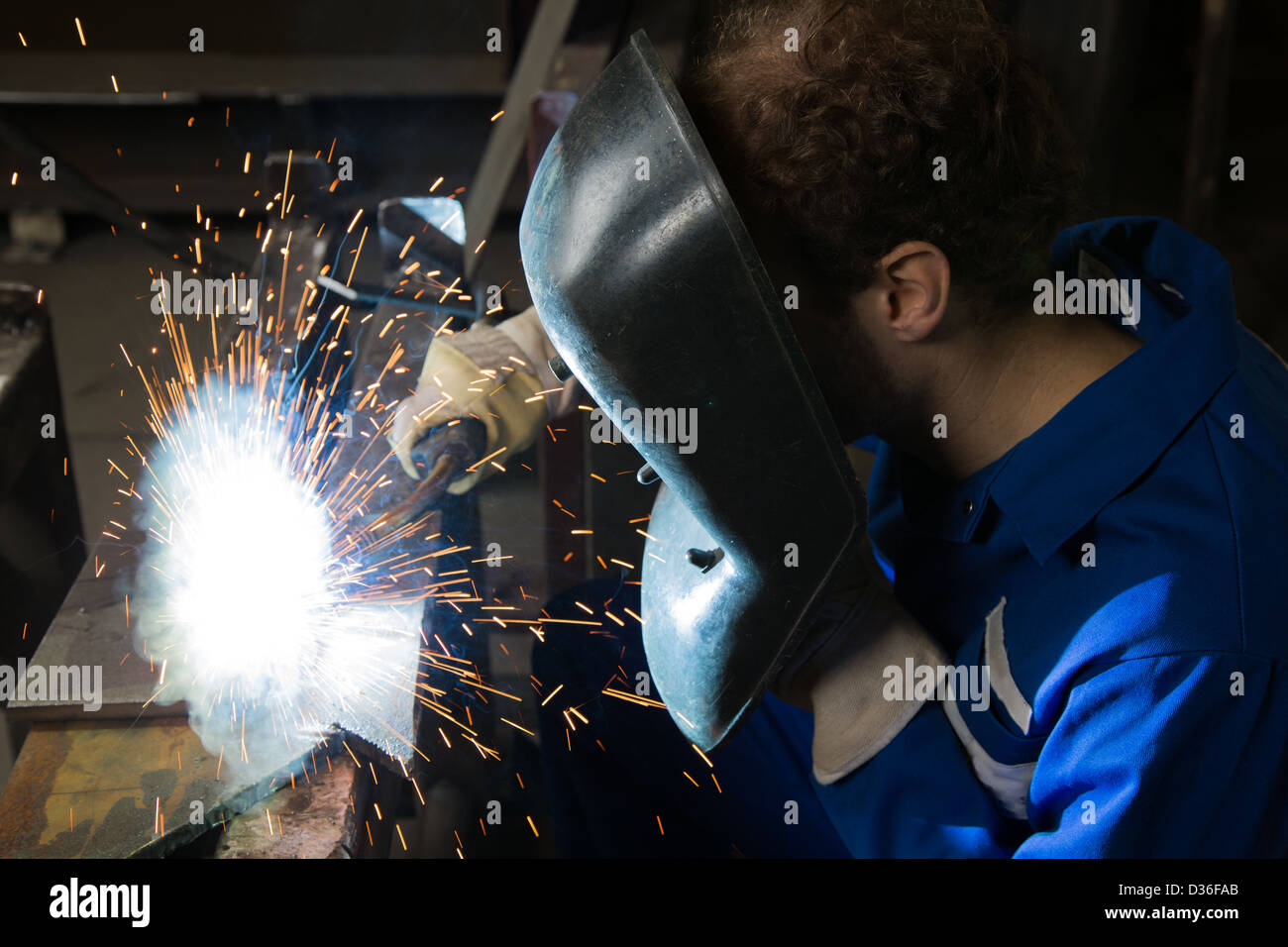 Man with welding helmet welding steel Stock Photo
