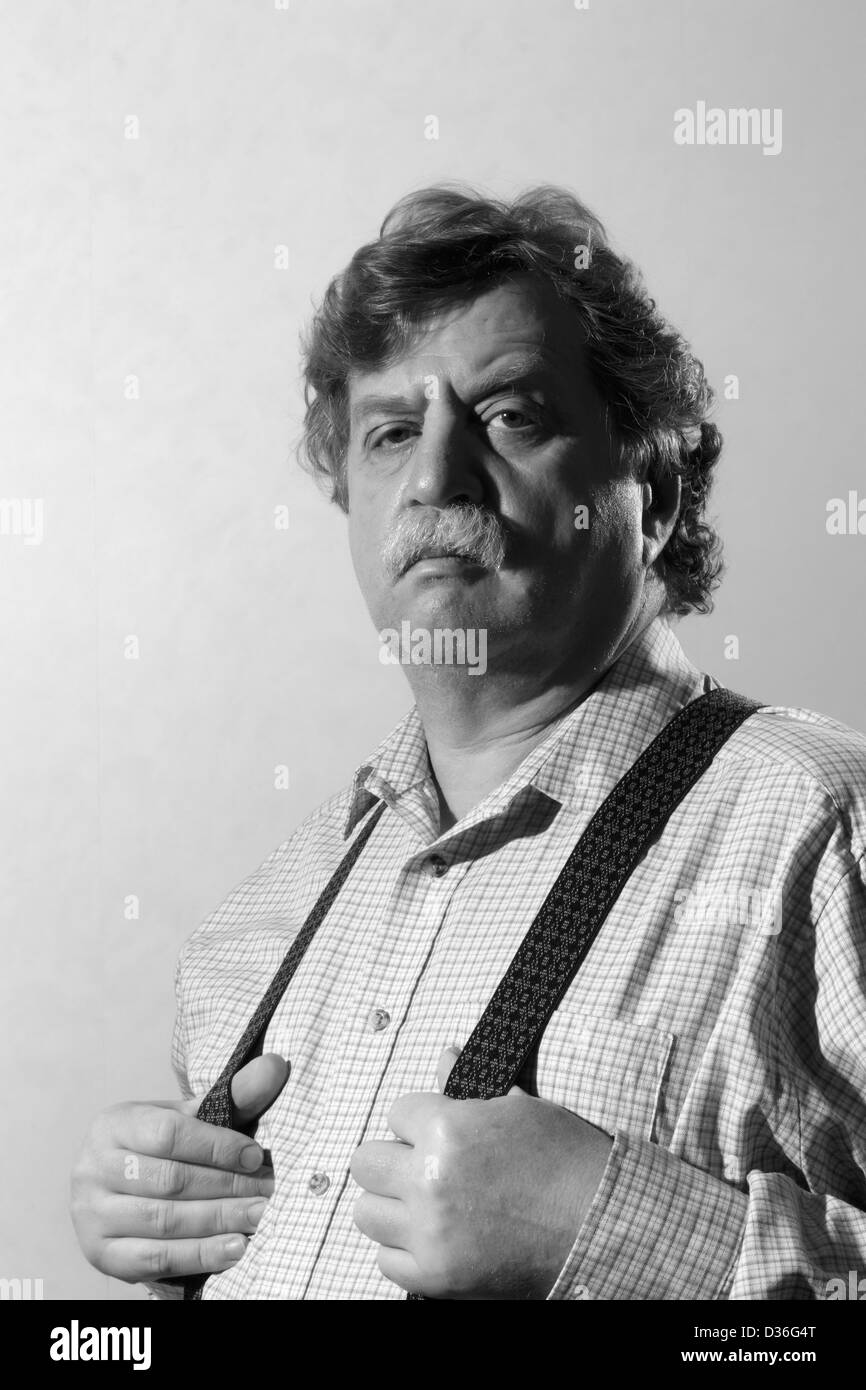 middle-aged man in a light shirt and suspenders, black and white  Stock Photo