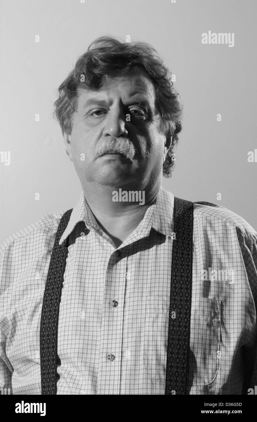 middle-aged man in a light shirt and suspenders, black and white  Stock Photo