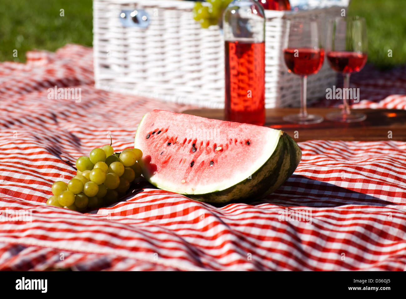 Wine and picnic basket on the grass Stock Photo - Alamy