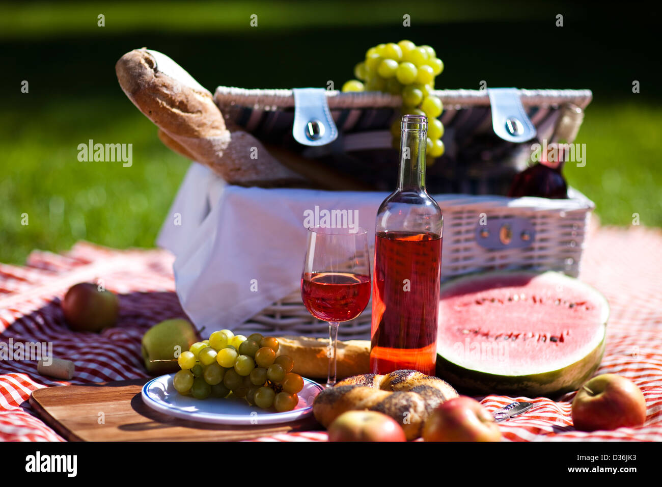Wine and picnic basket on the grass Stock Photo