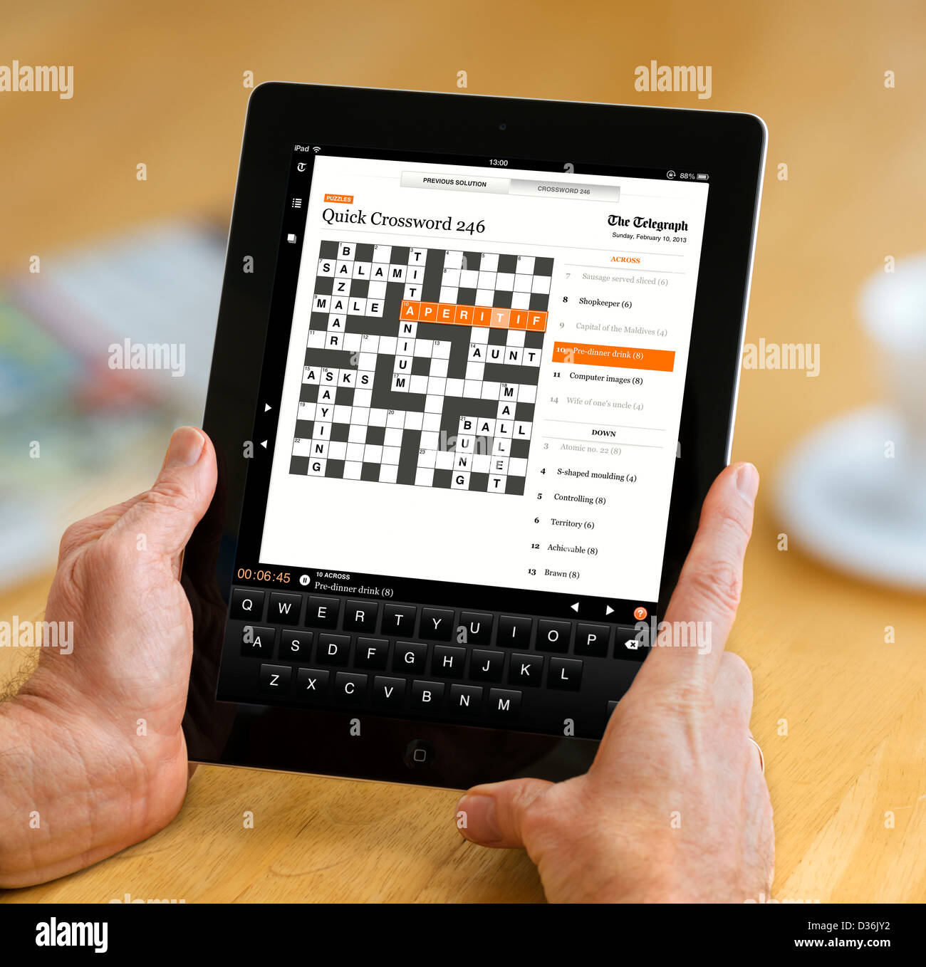 Doing the crossword on the Telegraph app on an Apple iPad 4th generation retina display tablet computer Stock Photo