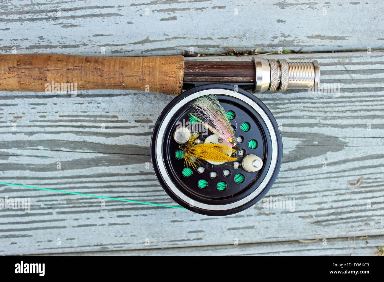 A flyrod and reel rests on a dock. Stock Photo