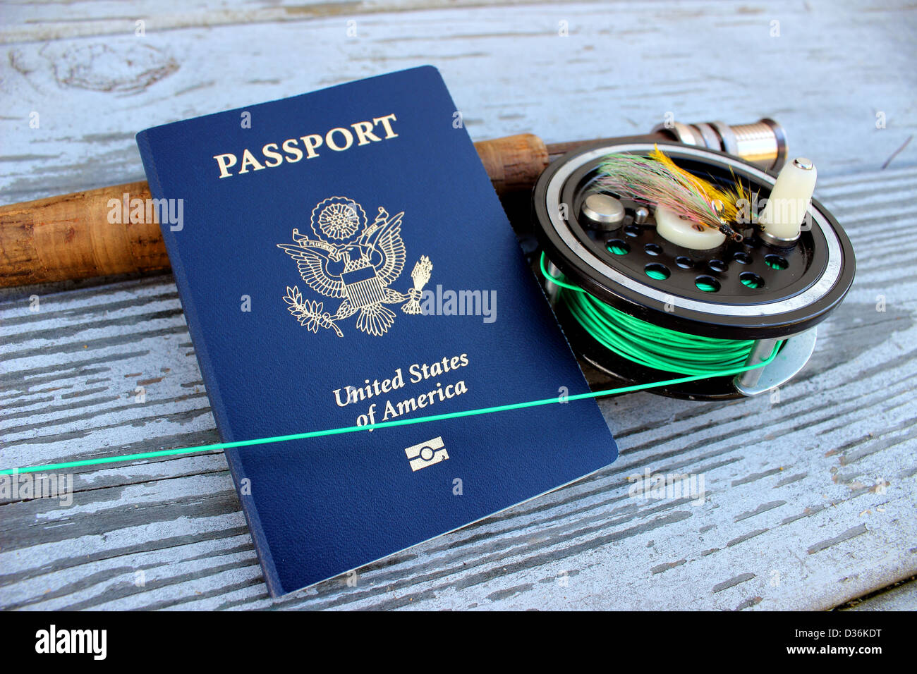 A flyrod and reel rests on a dock with a passport Stock Photo