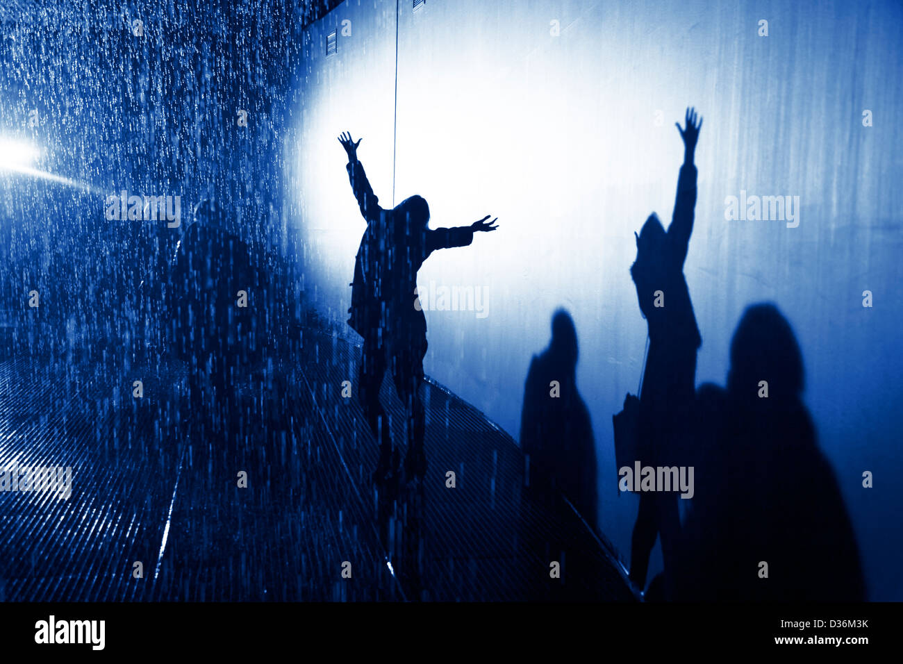 shadow of silhouette woman in the rain with arms open and outstretched enjoying the rain Stock Photo