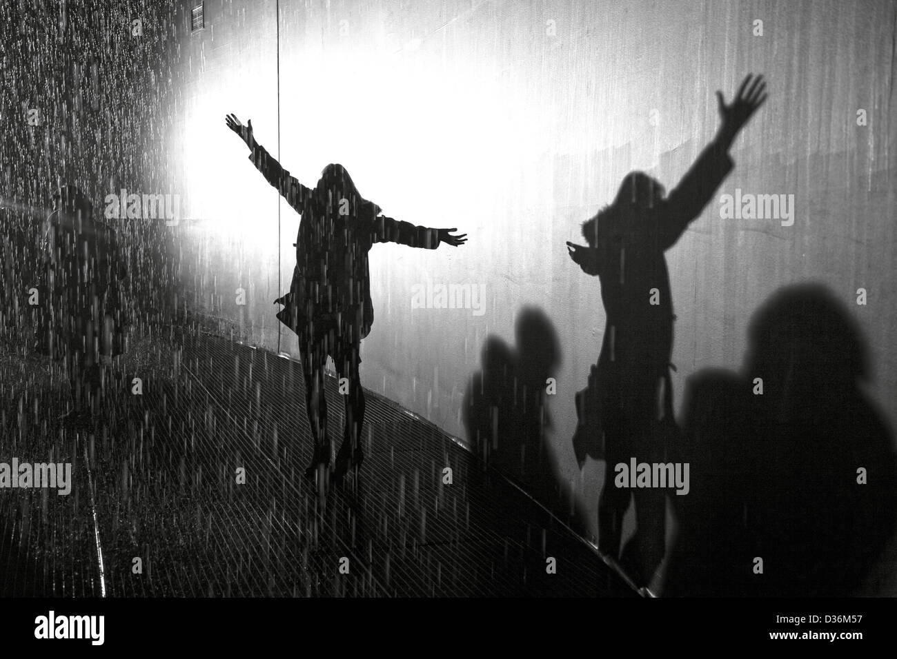 shadow of silhouette woman in the rain with arms open and outstretched enjoying the rain Stock Photo