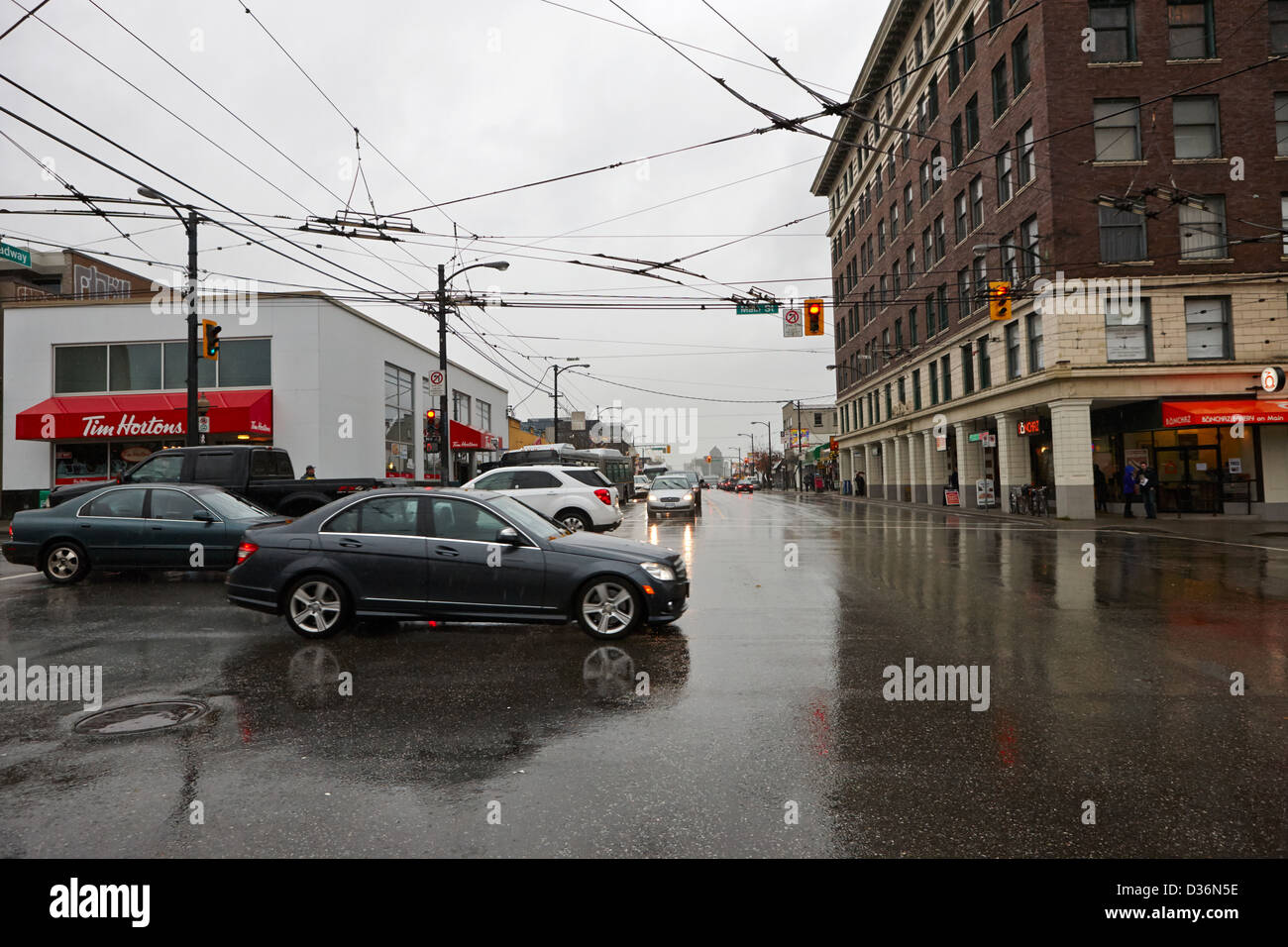 traffic at the junction of main and broadway on a wet rainy day Vancouver BC Canada Stock Photo