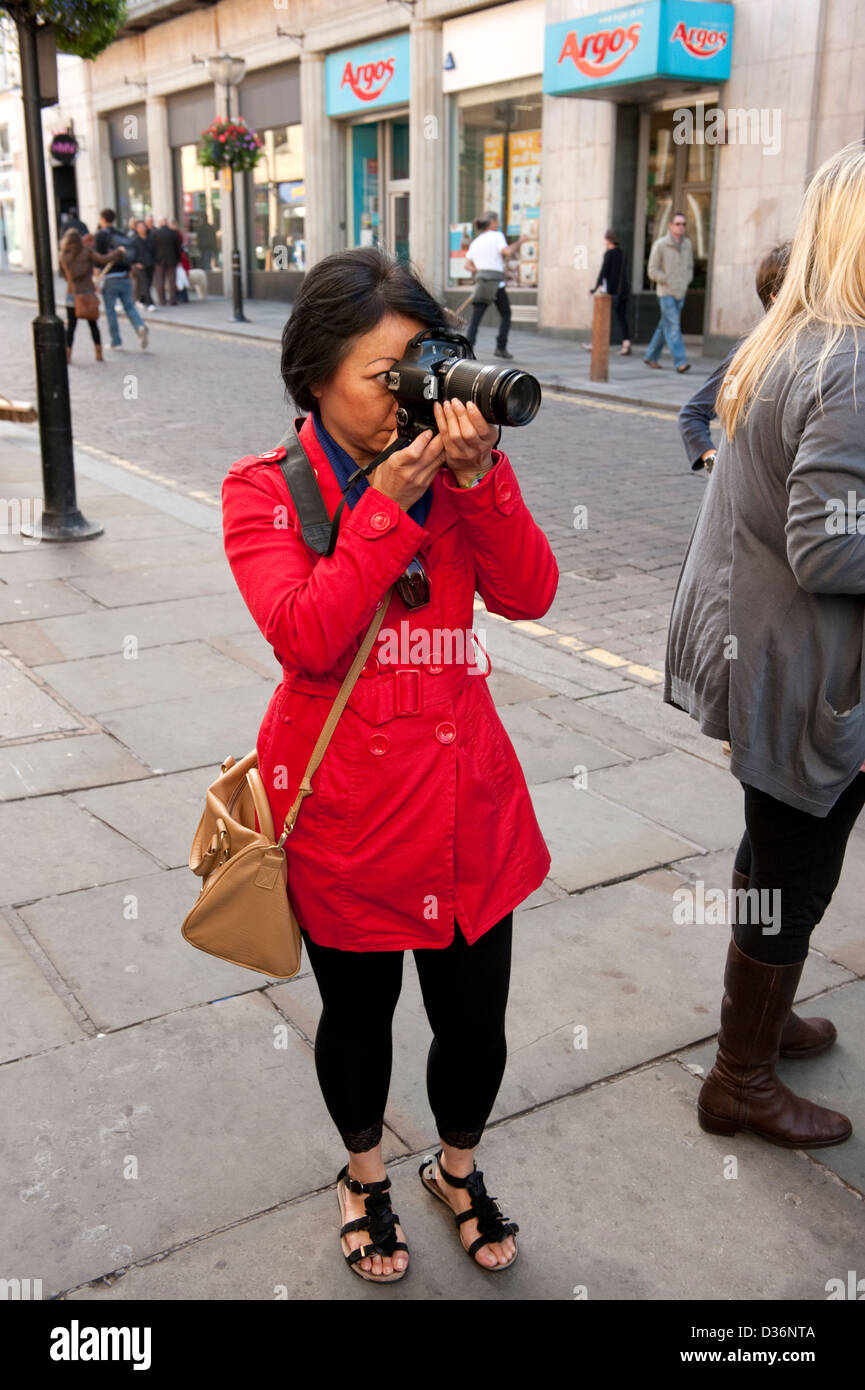 Chinese tourist taking photographs in Liverpool UK Stock Photo