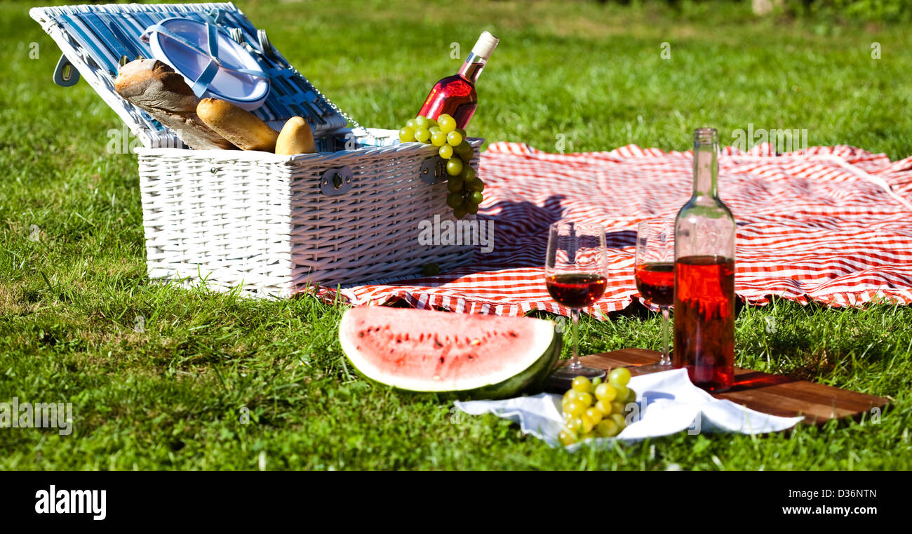Wine and picnic basket on the grass Stock Photo - Alamy