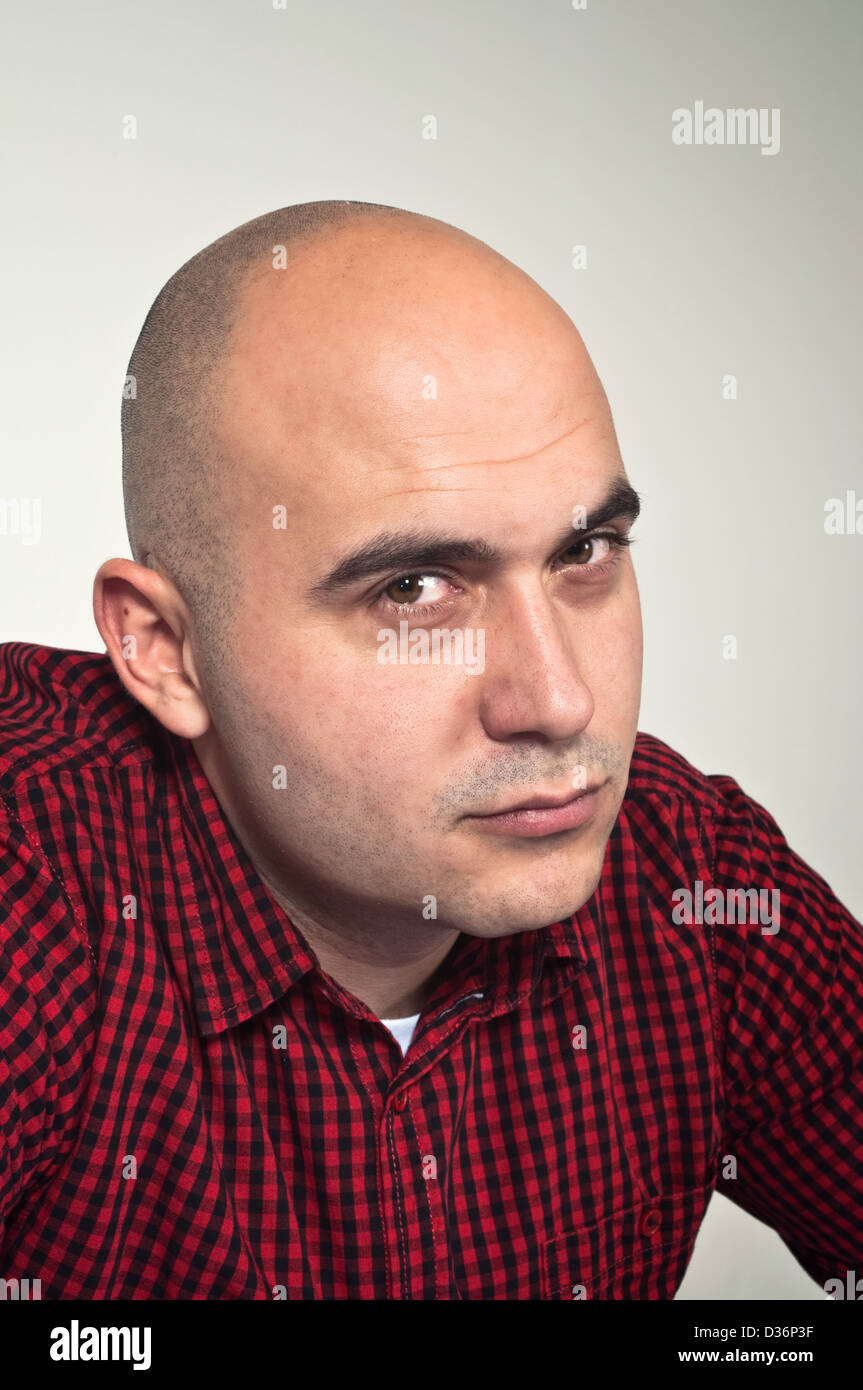 Portrait of a serious young adult bald man Stock Photo