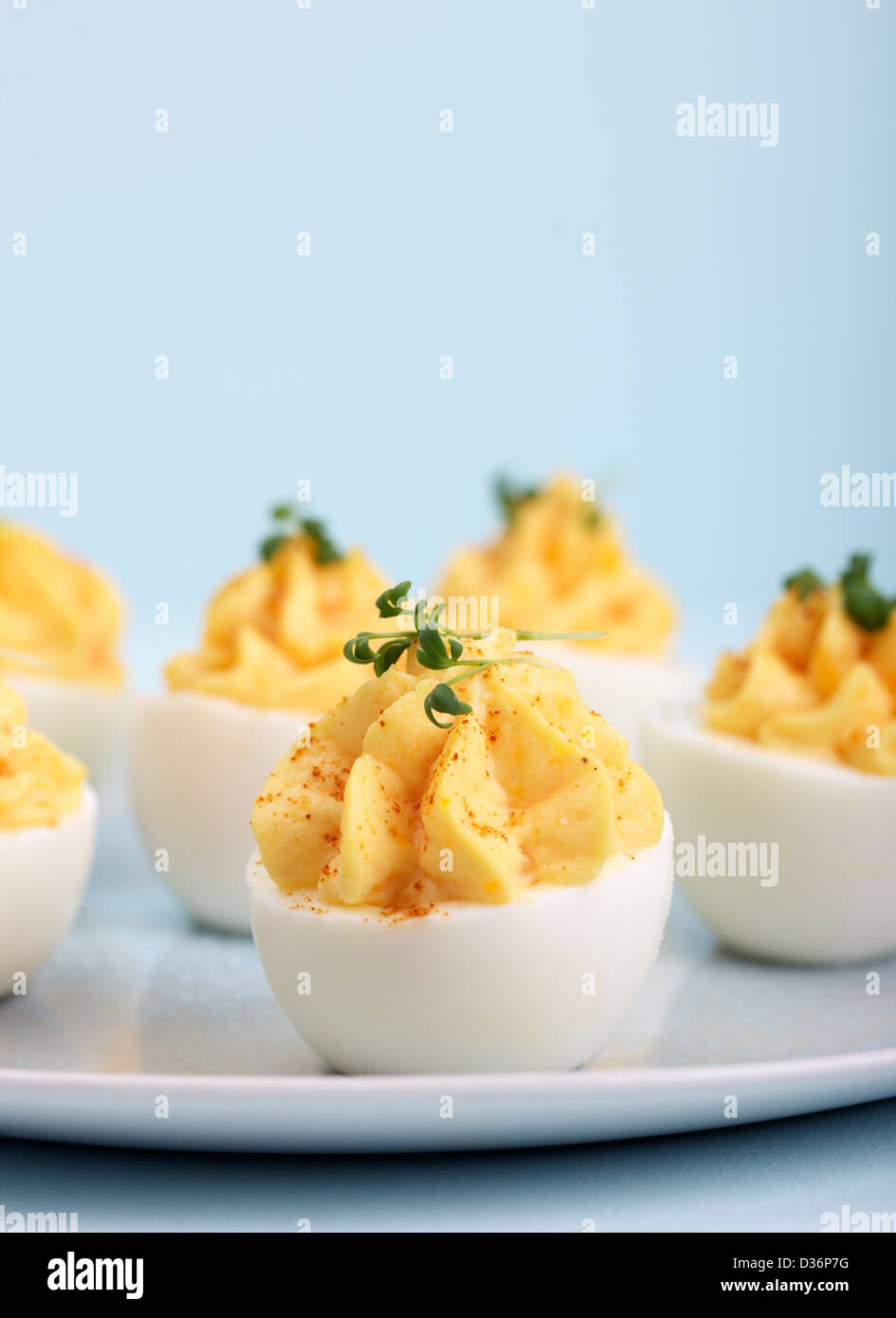 Eggs filled with boiled egg yolk, mixed with mayonnaise, sour cream, curry, sesoning. On top