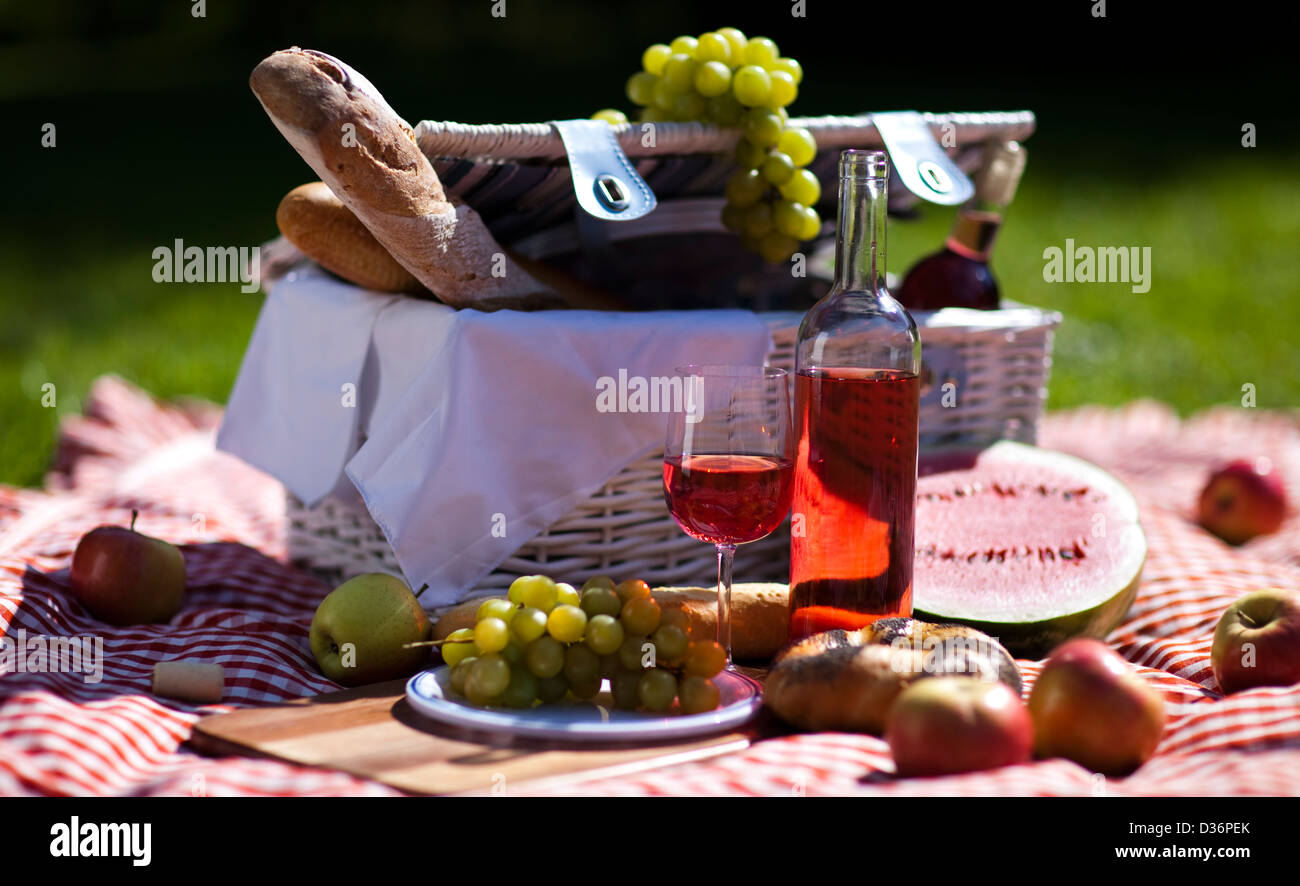 Wine and picnic basket on the grass Stock Photo