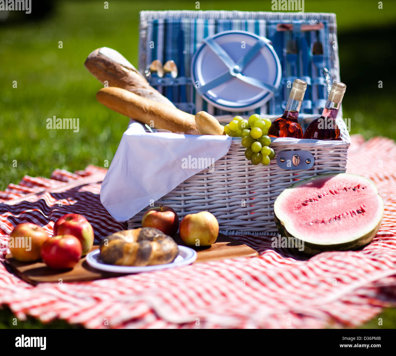 Picnic basket on green lawn Stock Photo