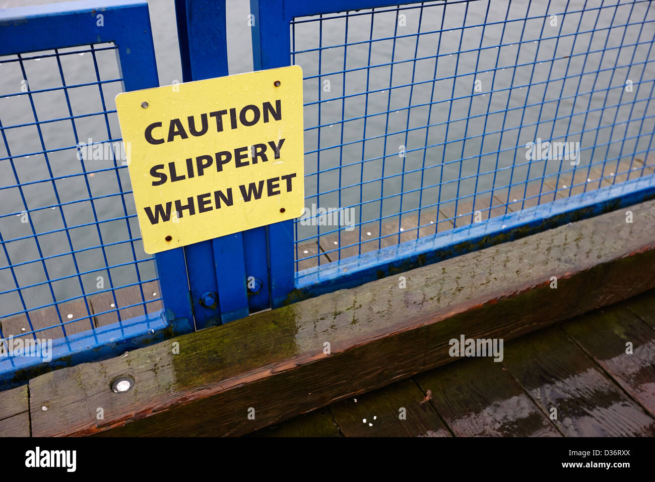 caution slippery when wet sign on wooden seafront walkway north
