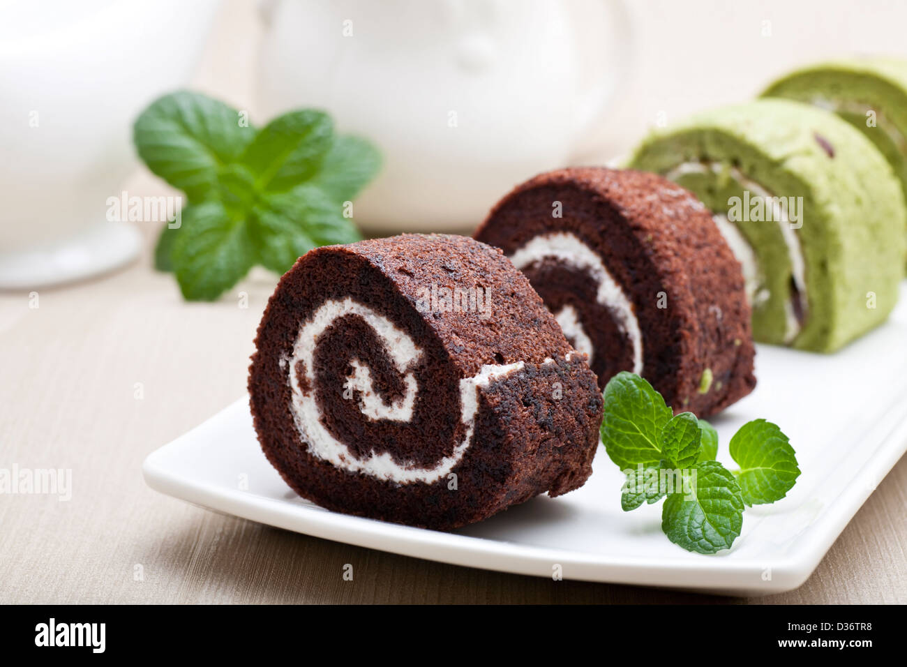 Chocolate swiss roll with green mint leaves Stock Photo