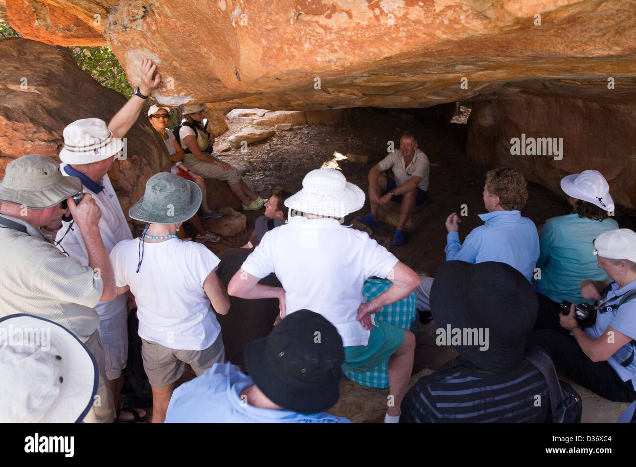 Mick Fogg discusses Aboriginal rock art found in a cave opening on Jar Island, Vansittart Bay, Western Australia. Stock Photo