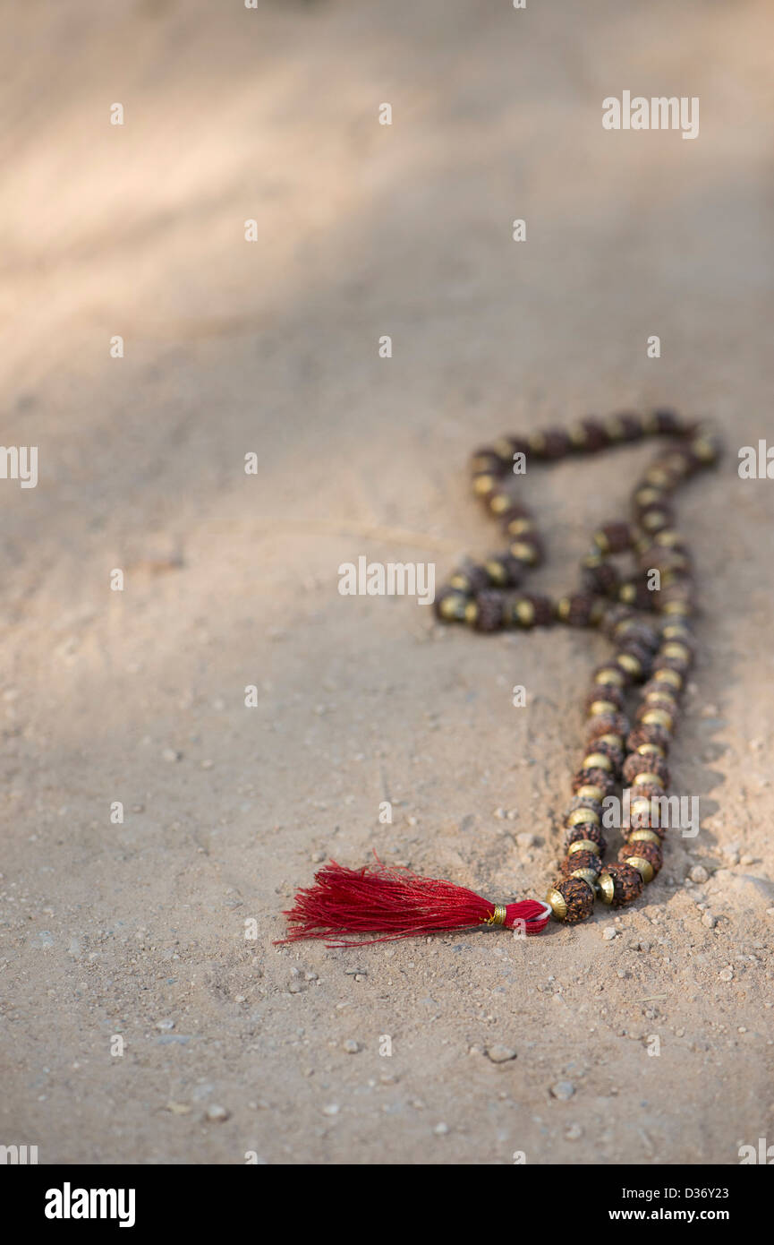 Indian Rudraksha / Japa Mala prayer beads on a dirt track in India Stock Photo