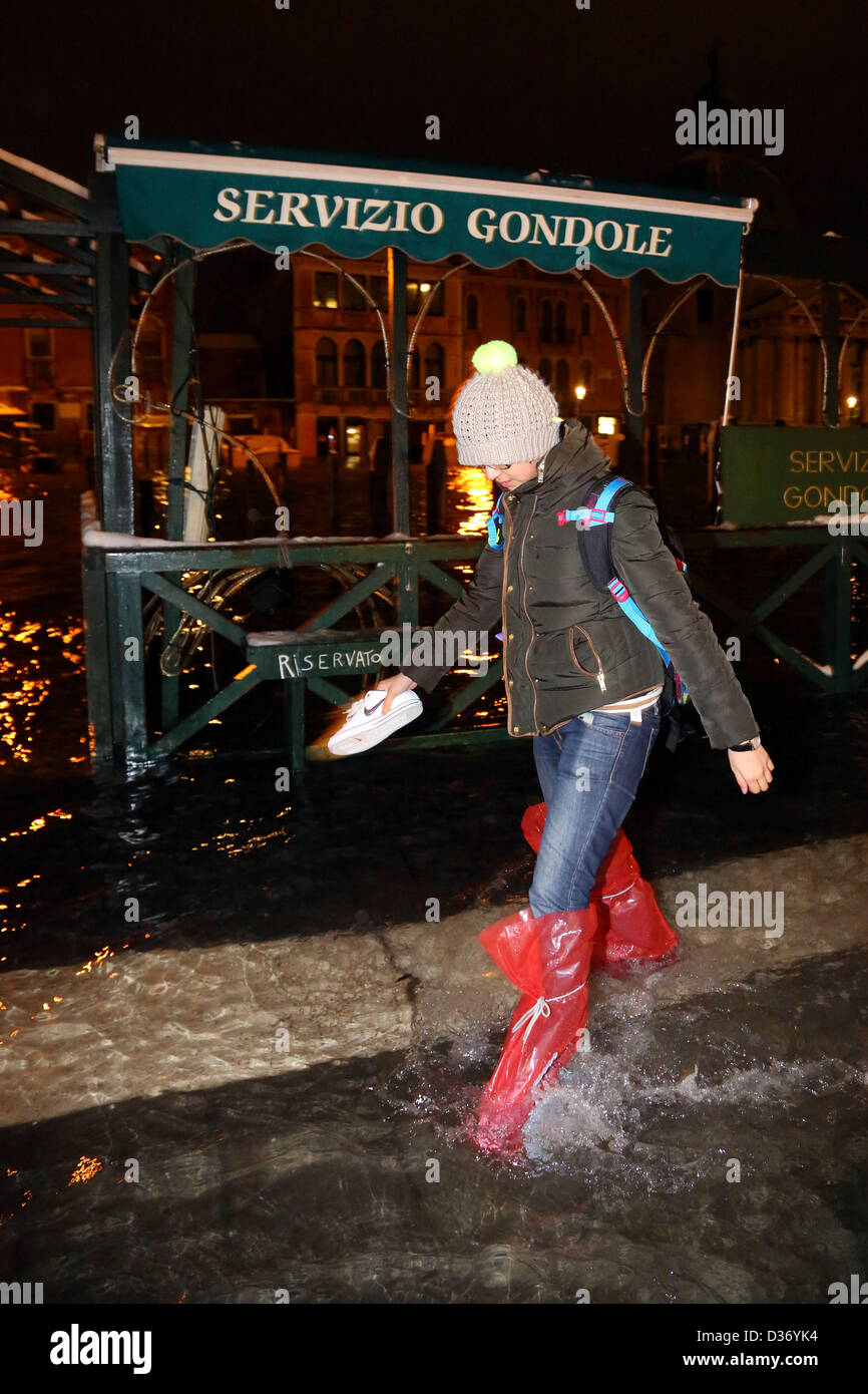 Venice, Italy. 12th February 2013. People wearing plastic bags on their feet  to keep the water out. After a day of snow that closed Marco Polo airport,  travellers forced to spend another