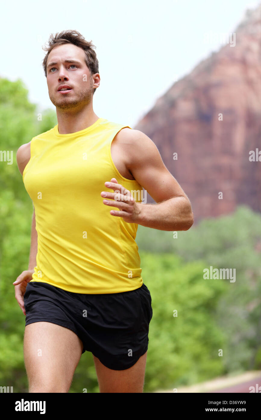 Running fitness man sprinting outdoors in beautiful landscape. Fit male