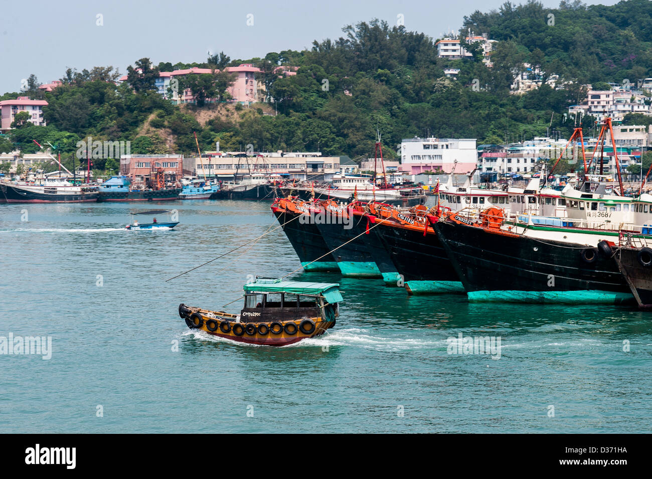 HONG KONG - SAR of CHINA: A little boat crosses Chuen Chau island's harbor in Hong Kong Stock Photo