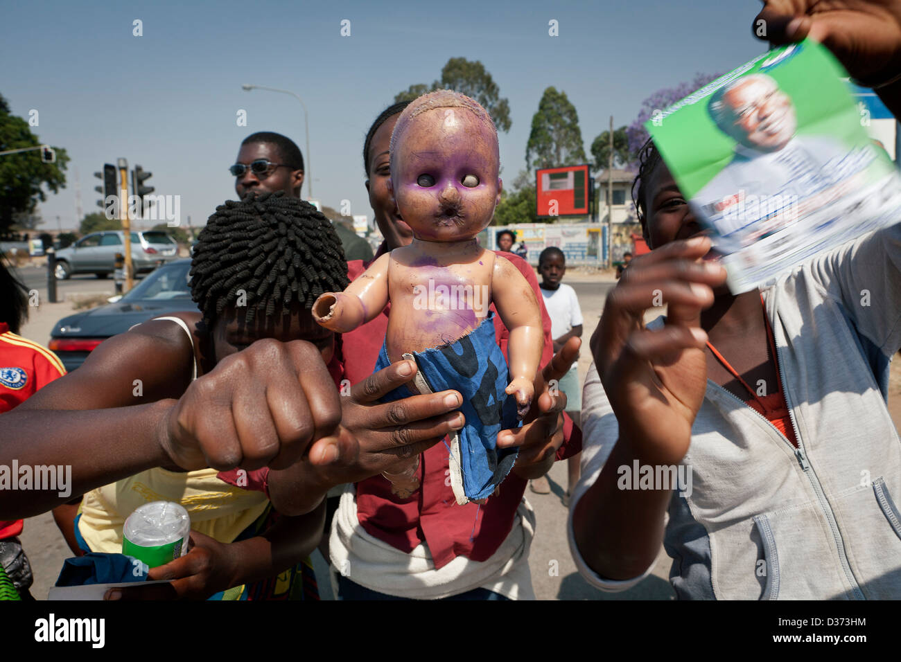 Supporters of President Michael Sata on the streets of Lusaka holding a doll which  wears the incumbent party's blue colours Stock Photo
