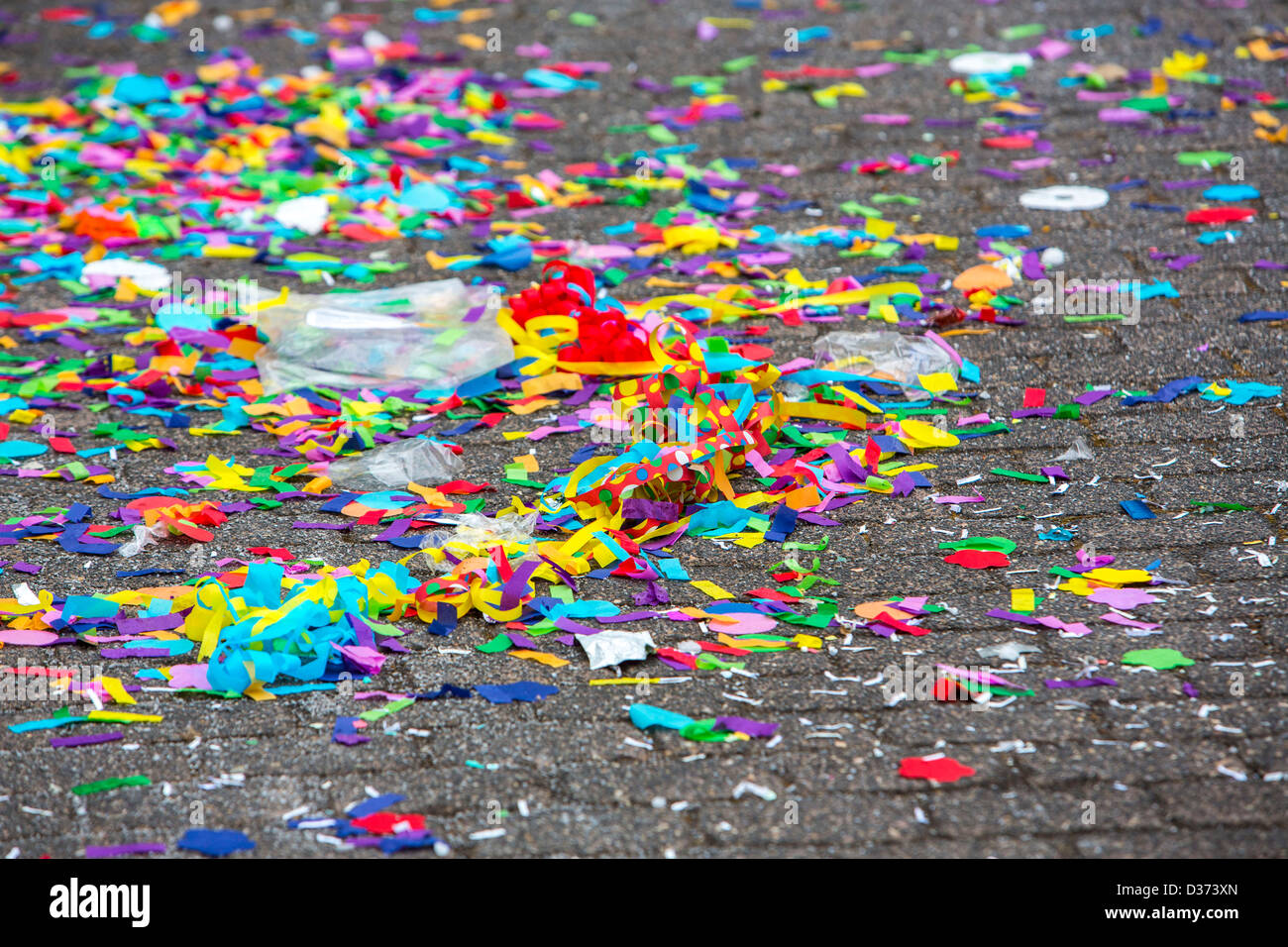 Colored confetti, paper waste on a street, after a carnival parade. Stock Photo