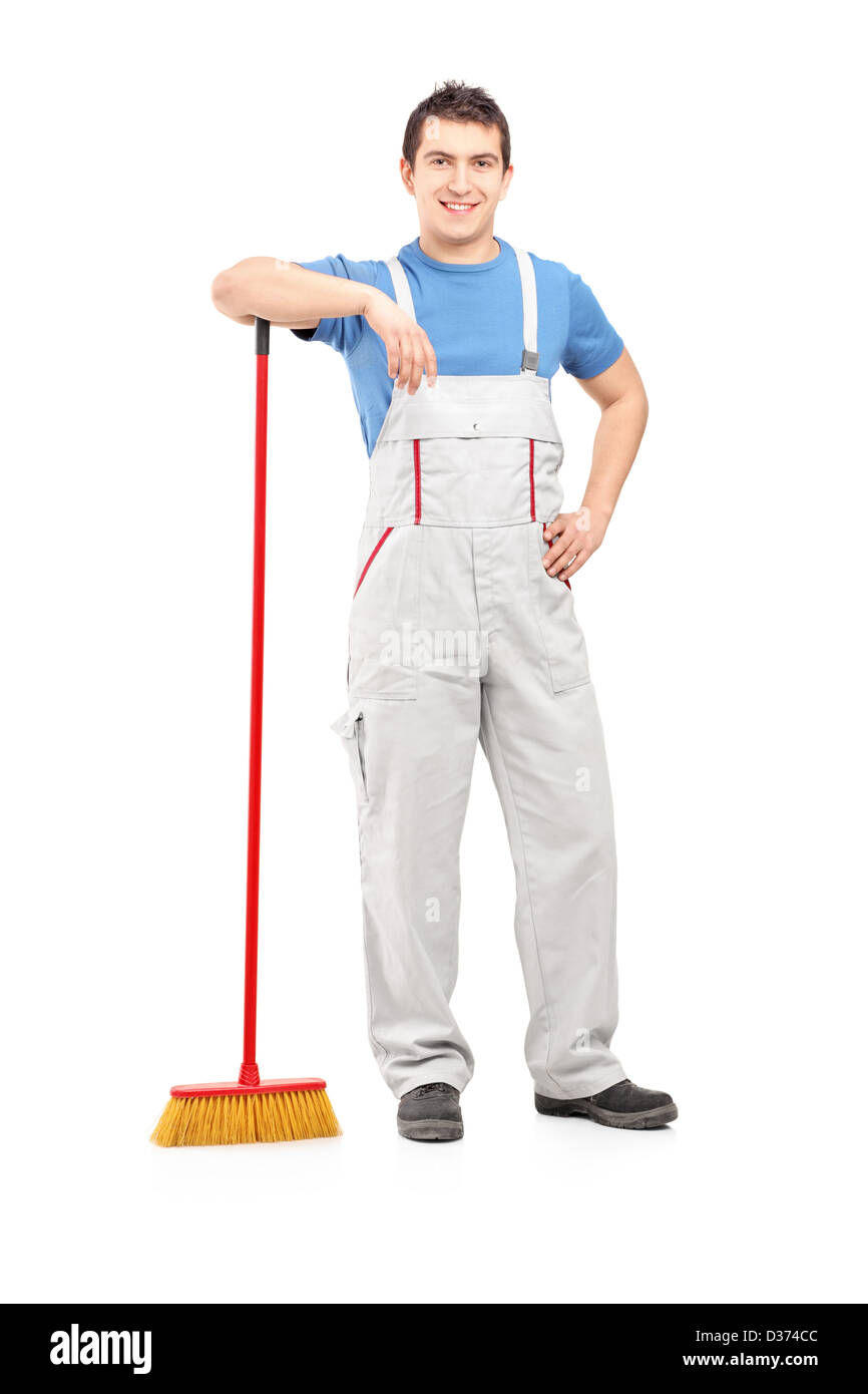 Full length portrait of a male cleaner holding a broom isolated on white background Stock Photo