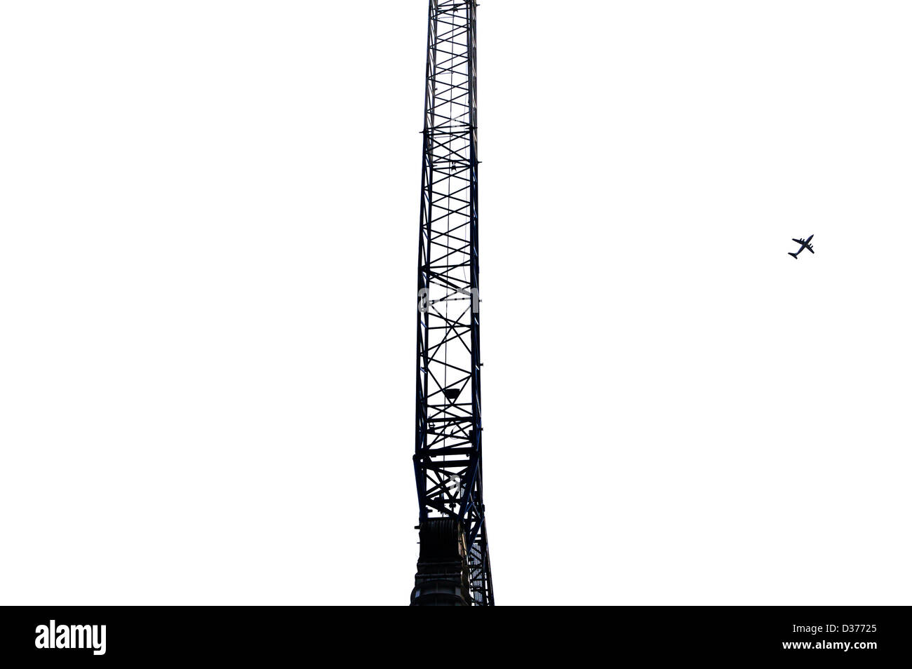 Crane against the sky with a plane in the sky in black and white Stock Photo