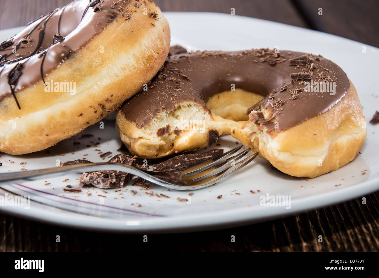 Chocolate Donuts on a plate on wooden background Stock Photo - Alamy