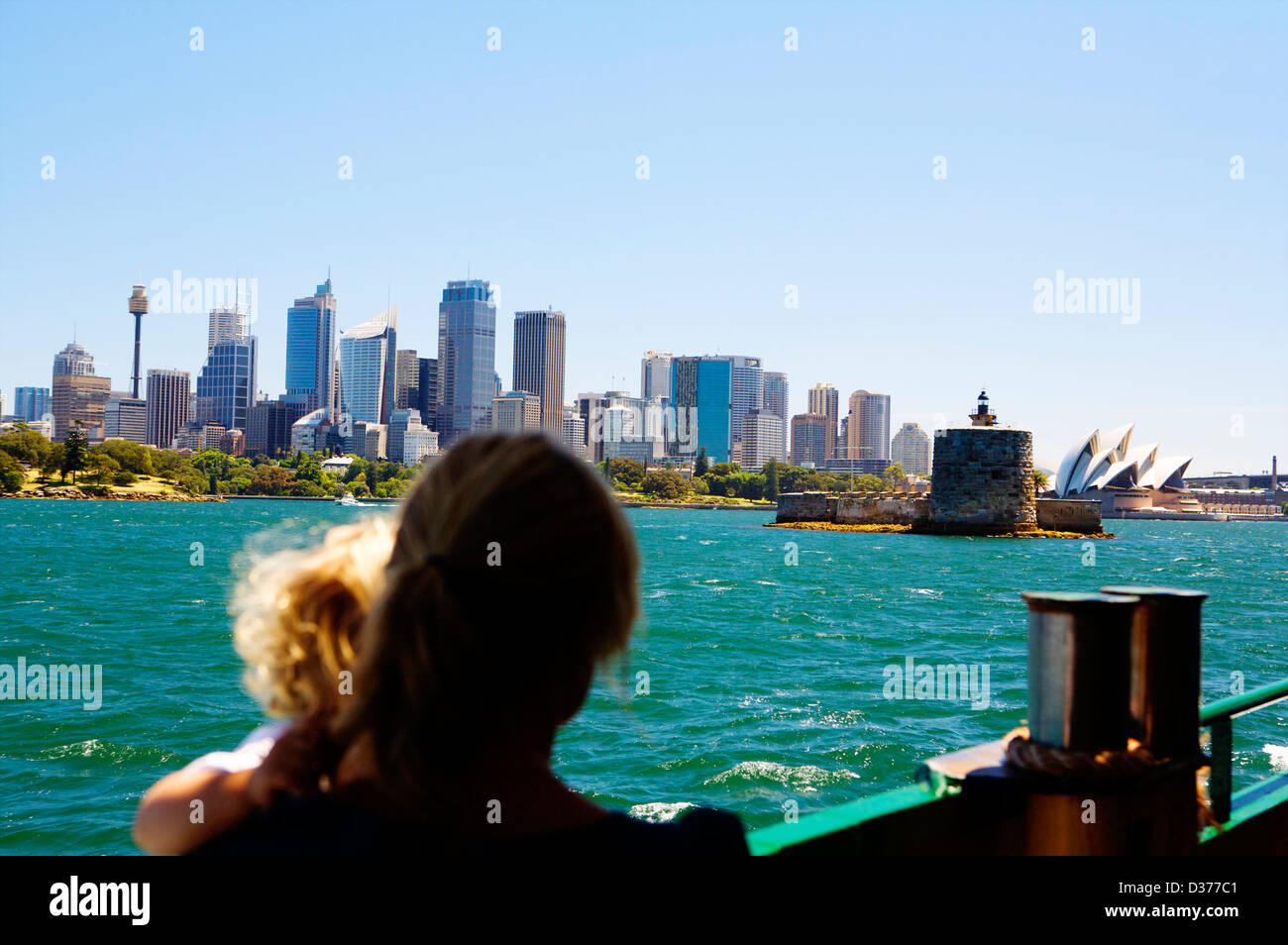 A woman and young child view the Sydney skyline from a boat on a sunny day from on board the Sydney Ferry as it approaches Manly. Stock Photo