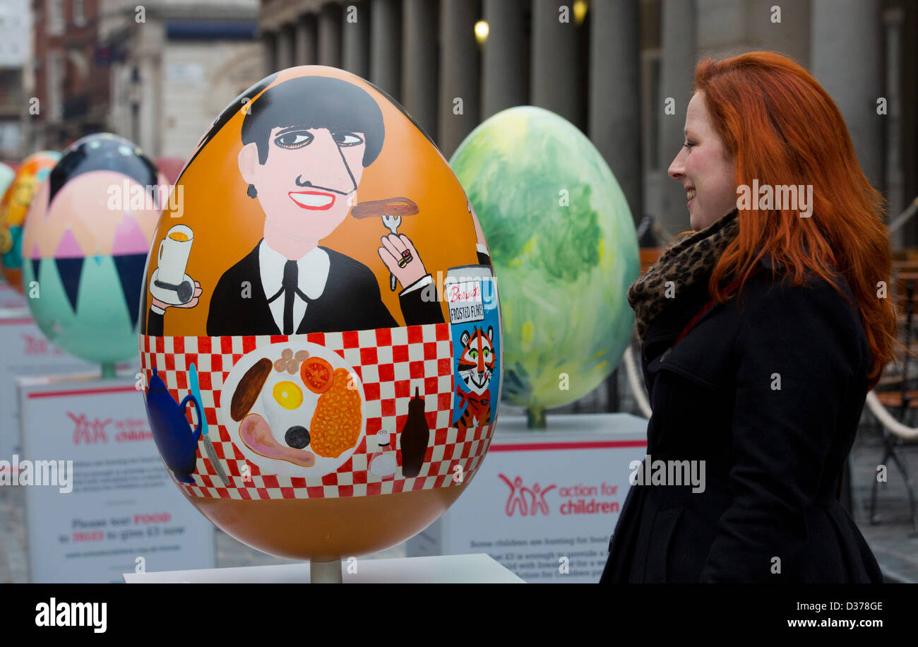 London, UK. 12th February 2013.  Catrin Mostyn Jones from North Wales encounters the face of Beatle Ringo Starr on one of the eggs. Over 100 giant Easter eggs designed by artists and designers were unveiled today in Covent Garden Piazza, London, to launch The Lindt Big Egg Hunt in support for the charity 'Action for Children'. For six weeks, from 12 February to 1 April 2013, giant Easter eggs will tour the country, from London's Covent Garden to Birmingham, Liverpool, Manchester, Glasgow and back to London in time for Easter. Photo: Nick Savage/Alamy Live News Stock Photo