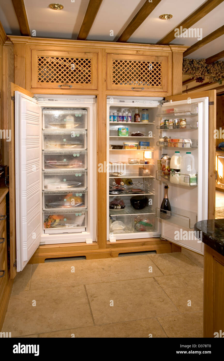 Well stocked fridge freezer in an upmarket solid wood fitted kitchen. Stock Photo