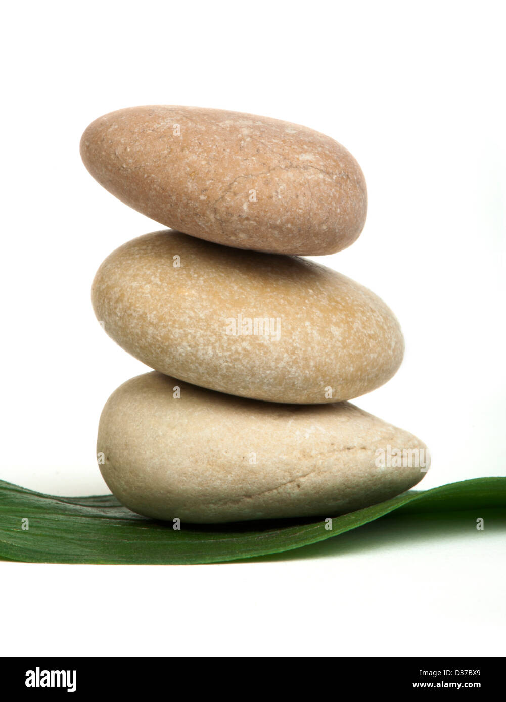 Stacked stones on base of green leafs. White isolated studio shot Stock ...