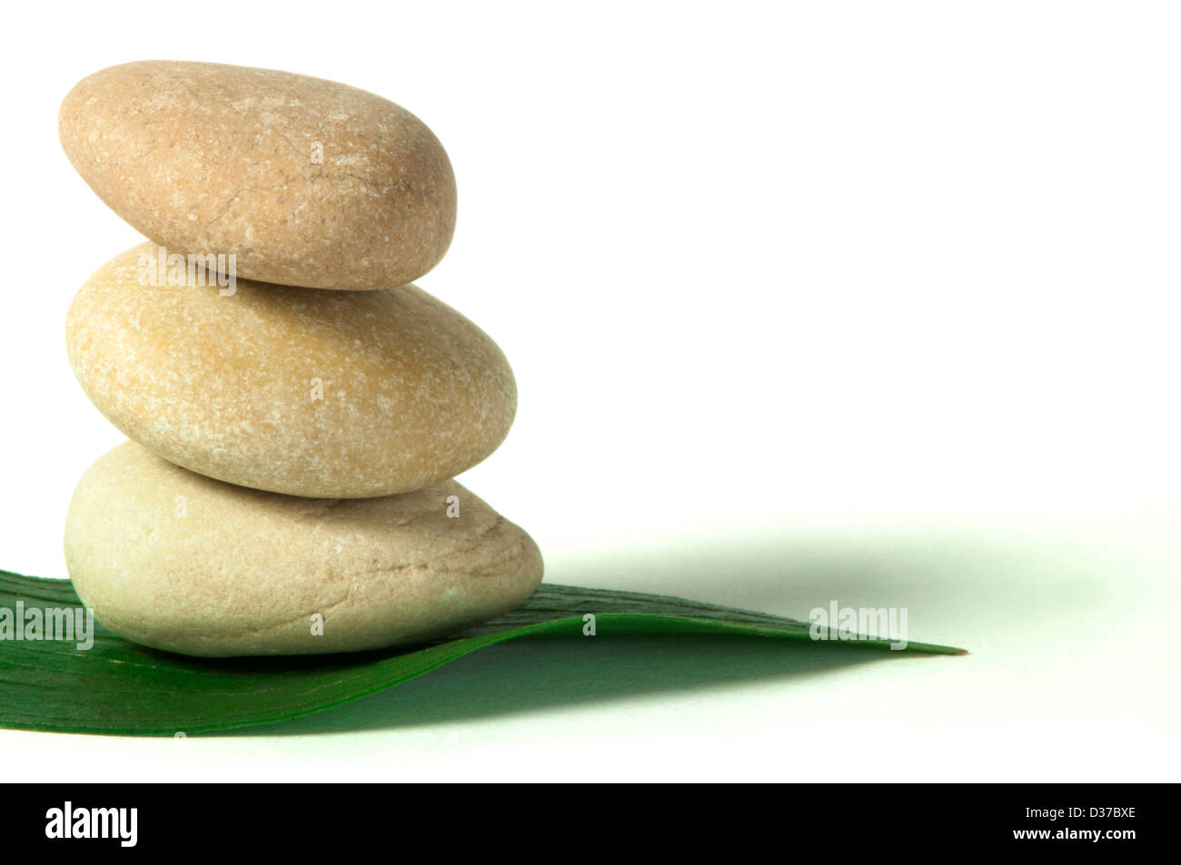 Stacked stones on base of green leafs. White isolated studio shot Stock ...