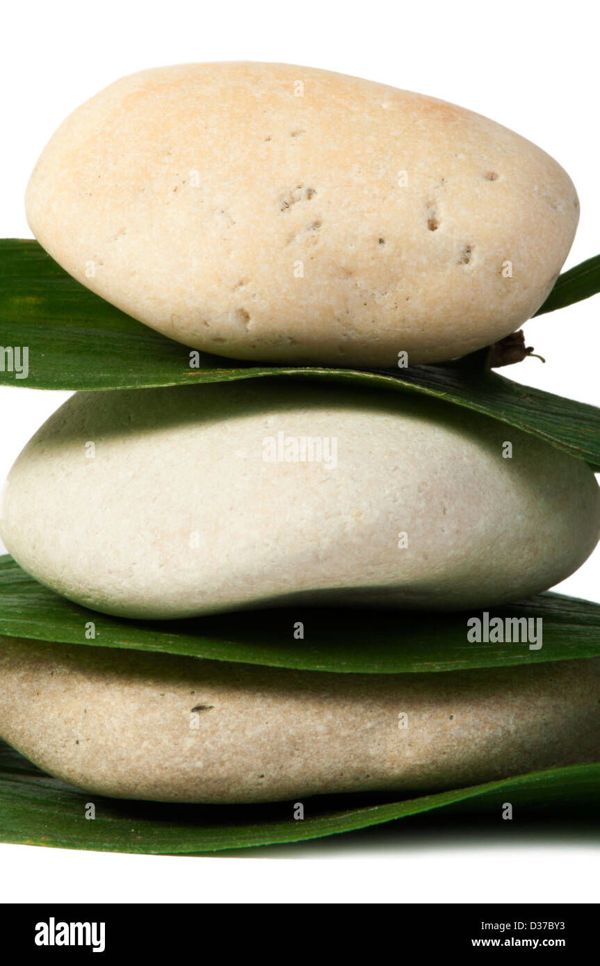 Stacked stones on base of green leafs. White isolated studio shot Stock ...