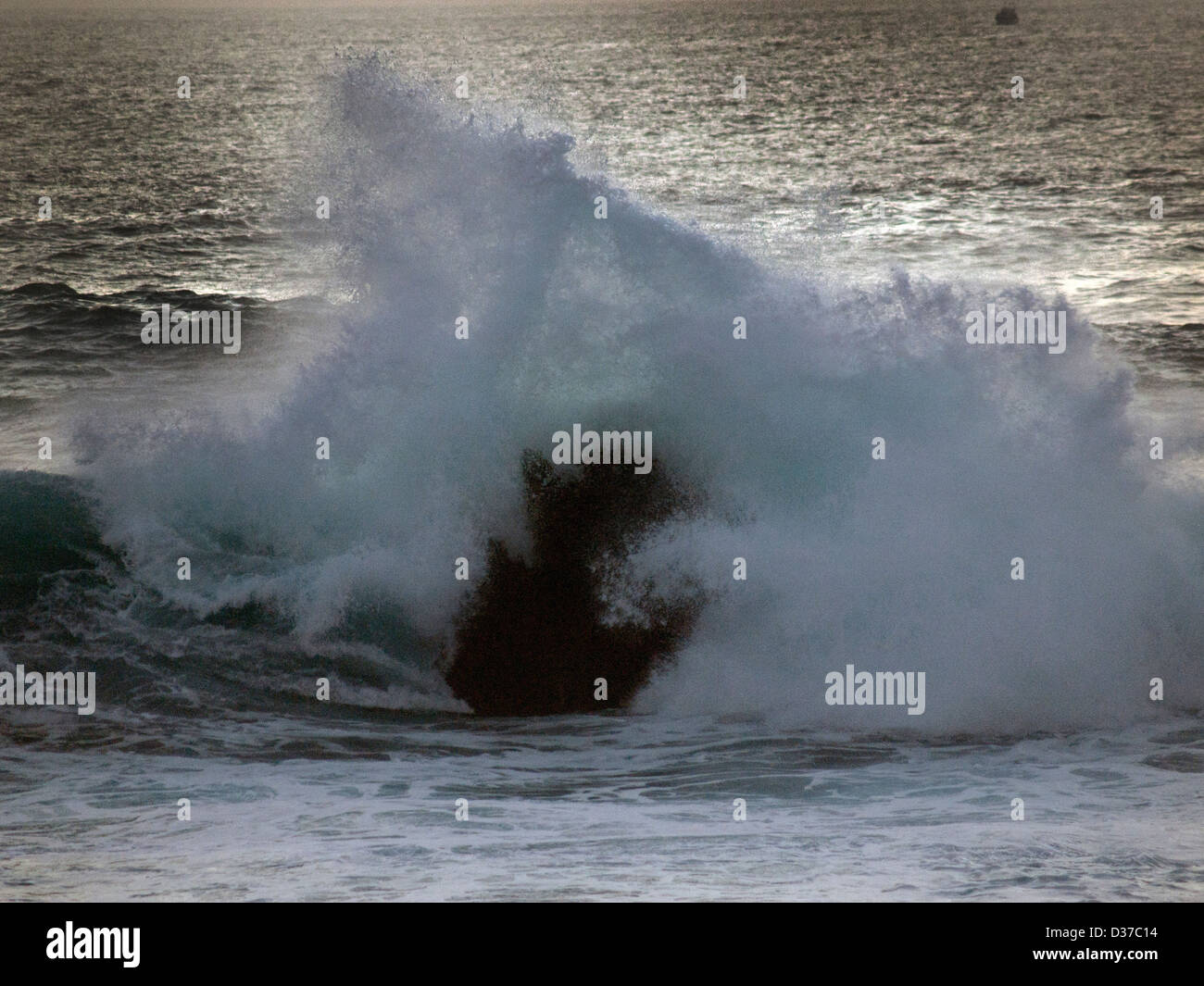 A wave breaks over a rock off the coast of Lanzarote Stock Photo - Alamy