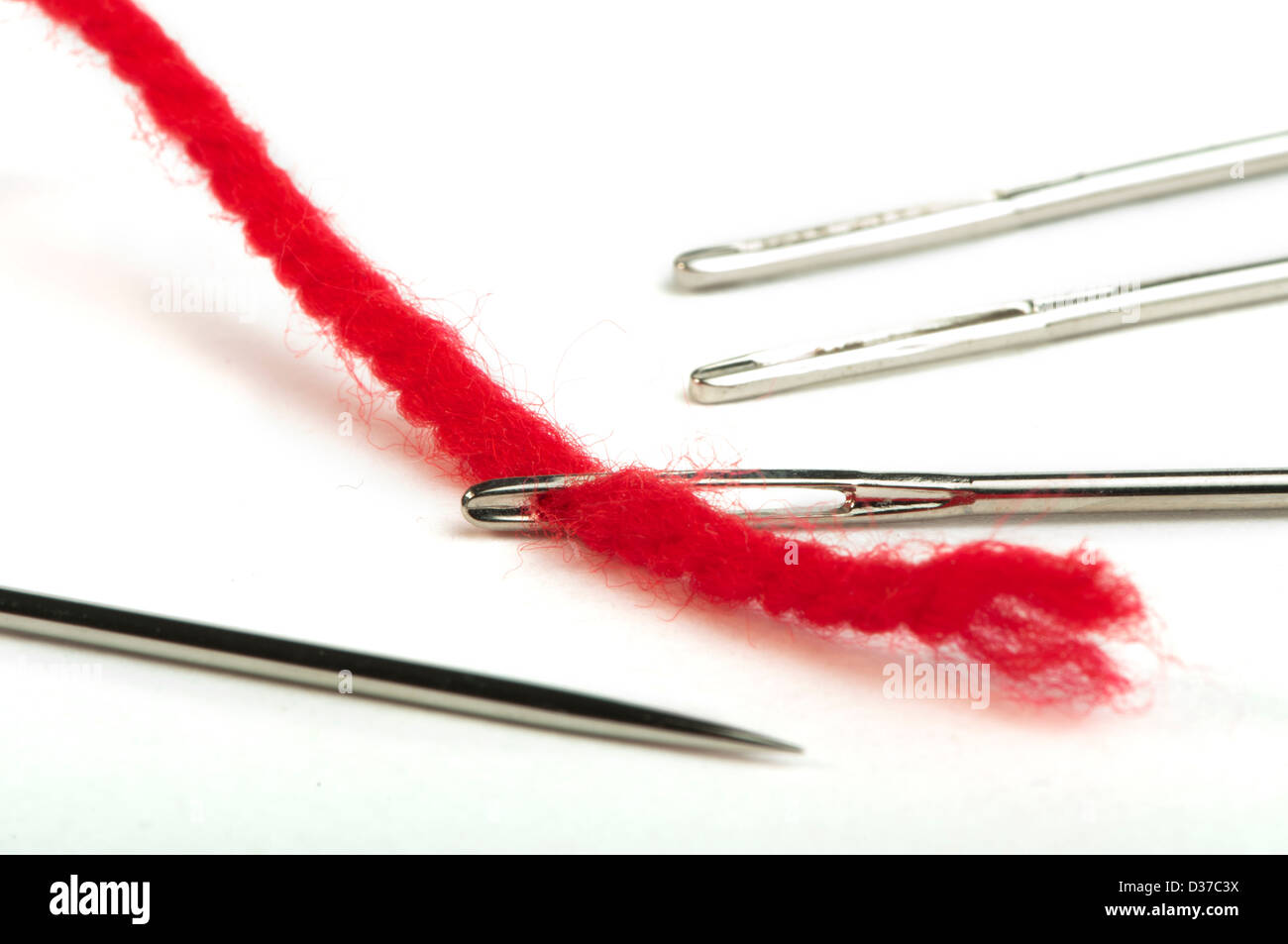 Sewing needles and red thread close up. White isolated Stock Photo Alamy