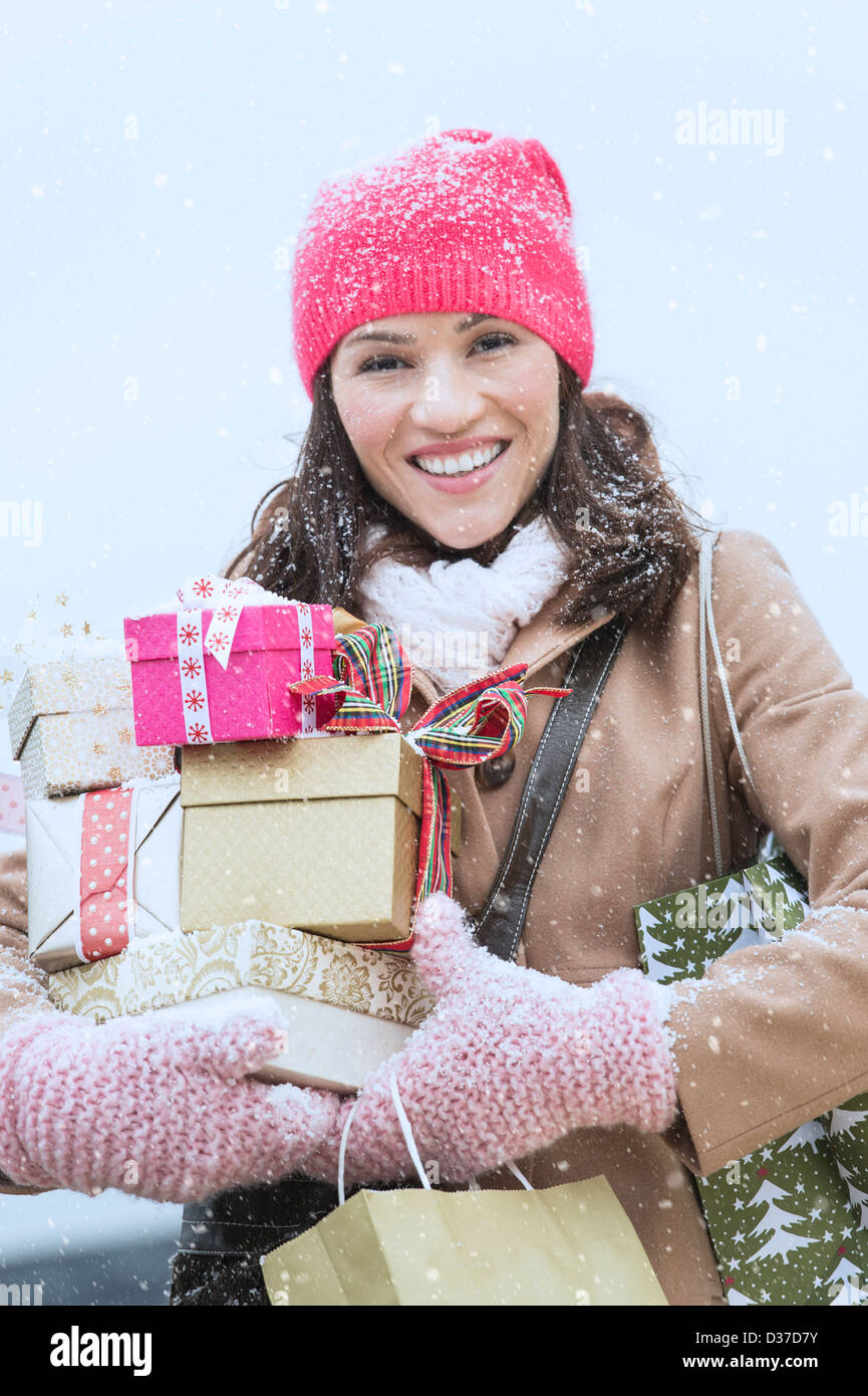 USA, New Jersey, Jersey City, Portrait of woman in winter clothes carrying presents Stock Photo