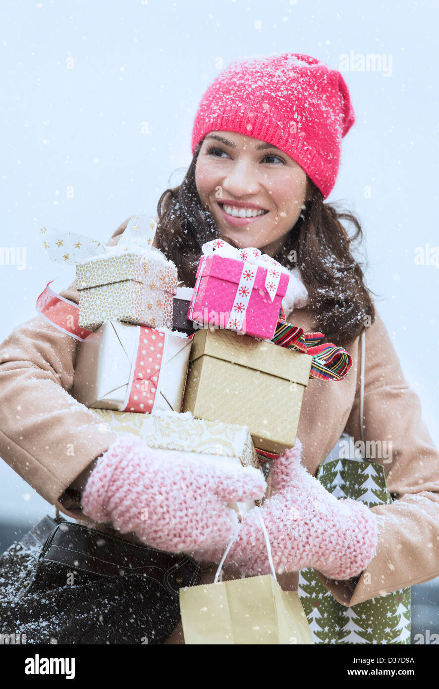 USA, New Jersey, Jersey City, Portrait of woman in winter clothes carrying presents Stock Photo