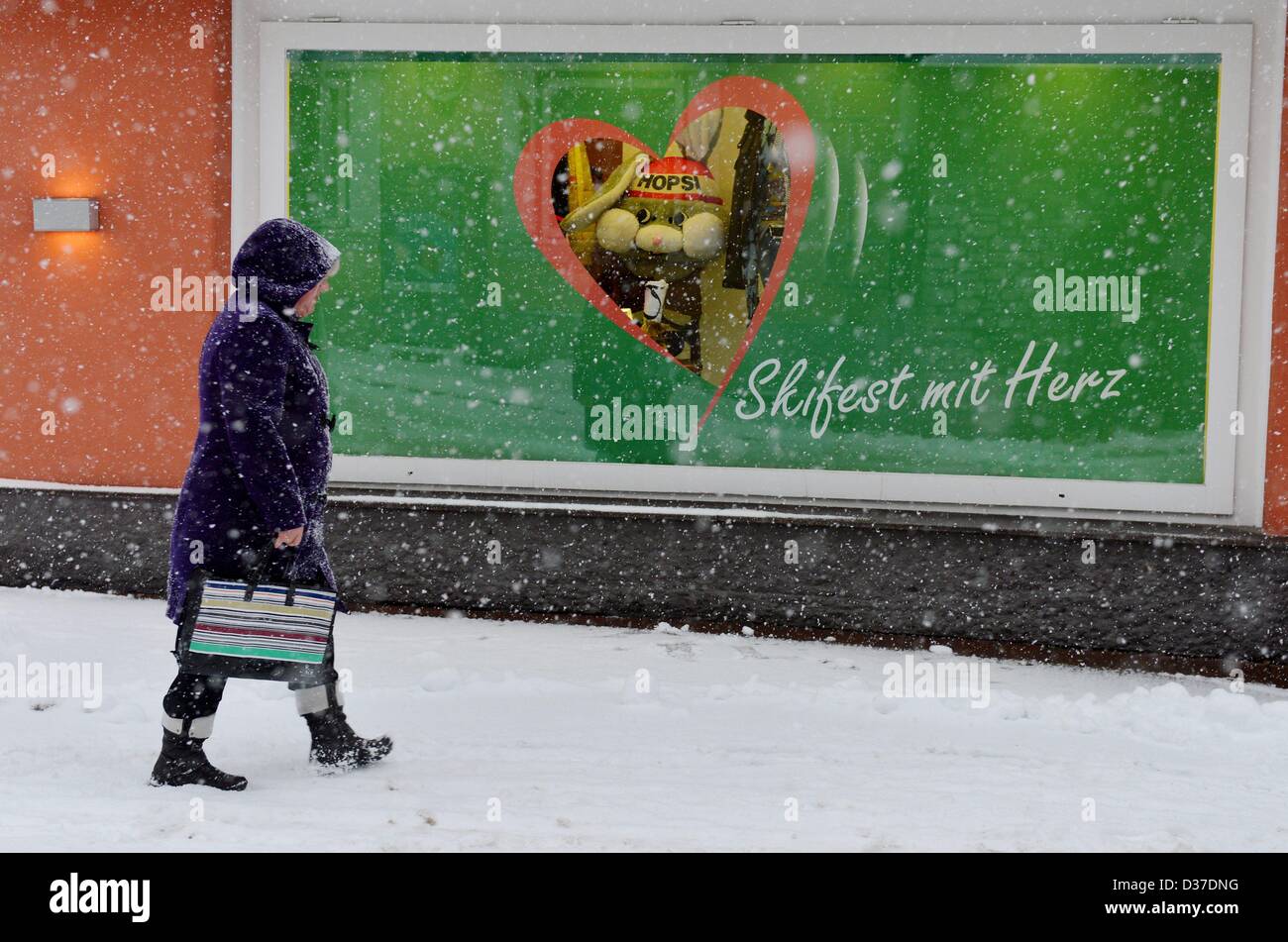 A woman passes the window of a store in which the maskot of the Ski alpin WM 'Hopsi' can be seen. Photo: Frank May Stock Photo