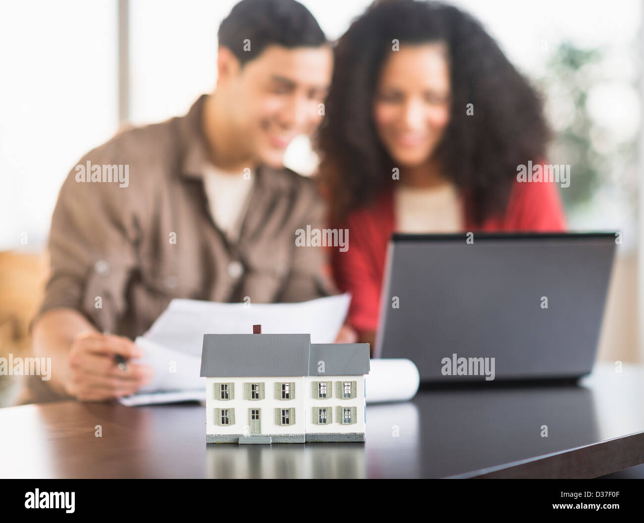 USA, New Jersey, Jersey City, Smiling couple planning home ownership with model home Stock Photo