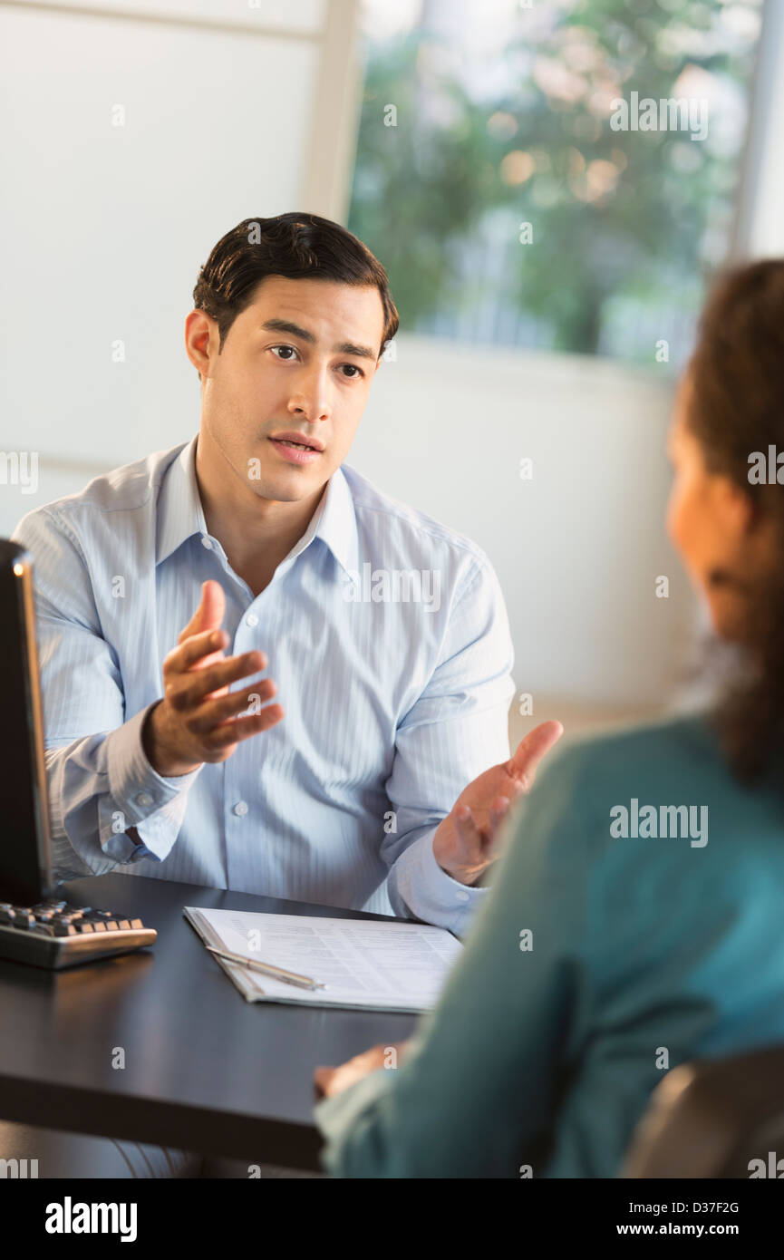 USA, New Jersey, Jersey City, Man and woman talking at desk during job interview Stock Photo