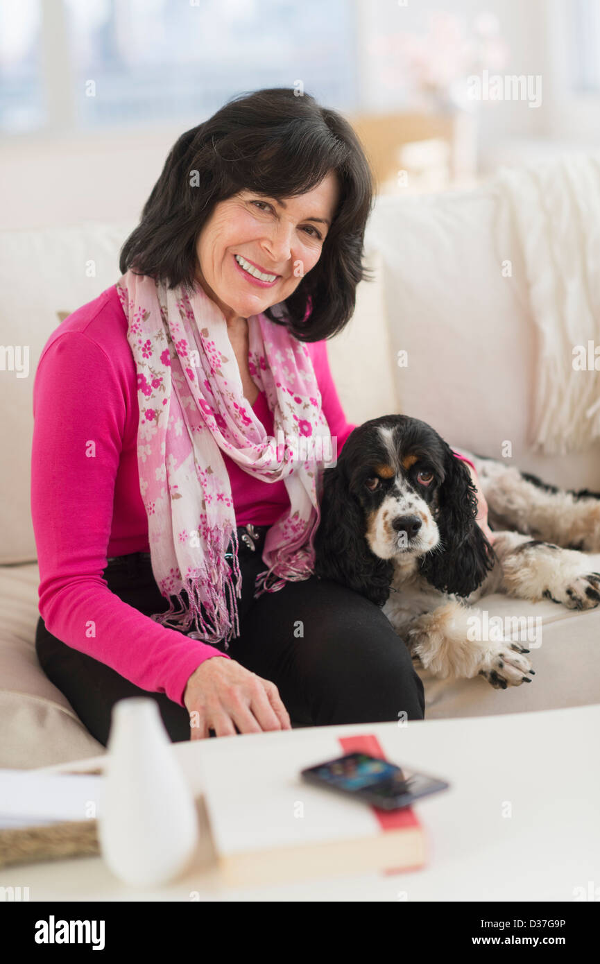 USA, New Jersey, Jersey City, Portrait of senior woman sitting on sofa with her dog Stock Photo