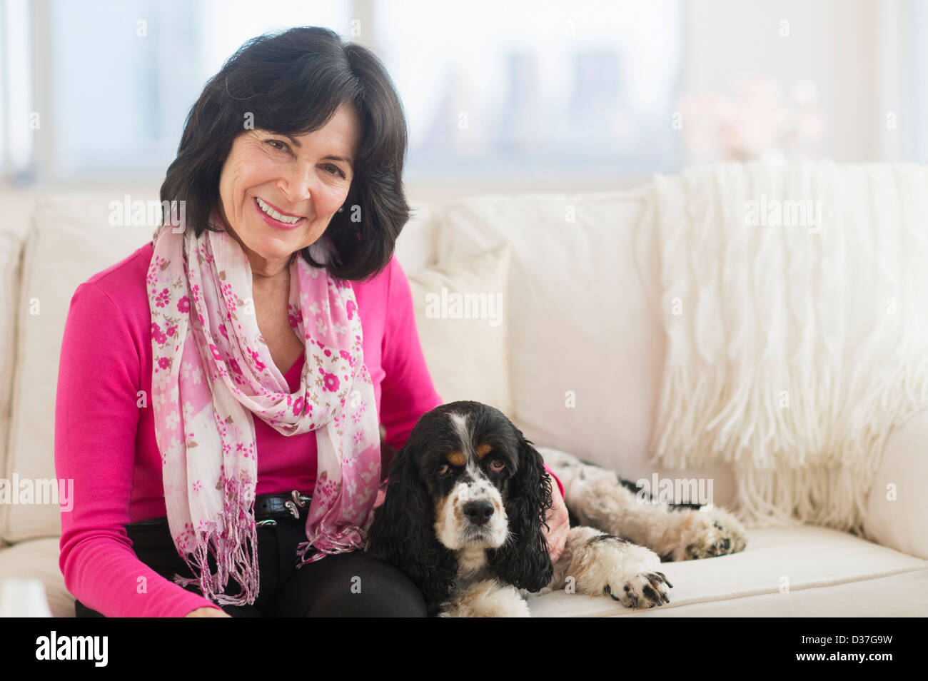 USA, New Jersey, Jersey City, Portrait of senior woman sitting on sofa with her dog Stock Photo