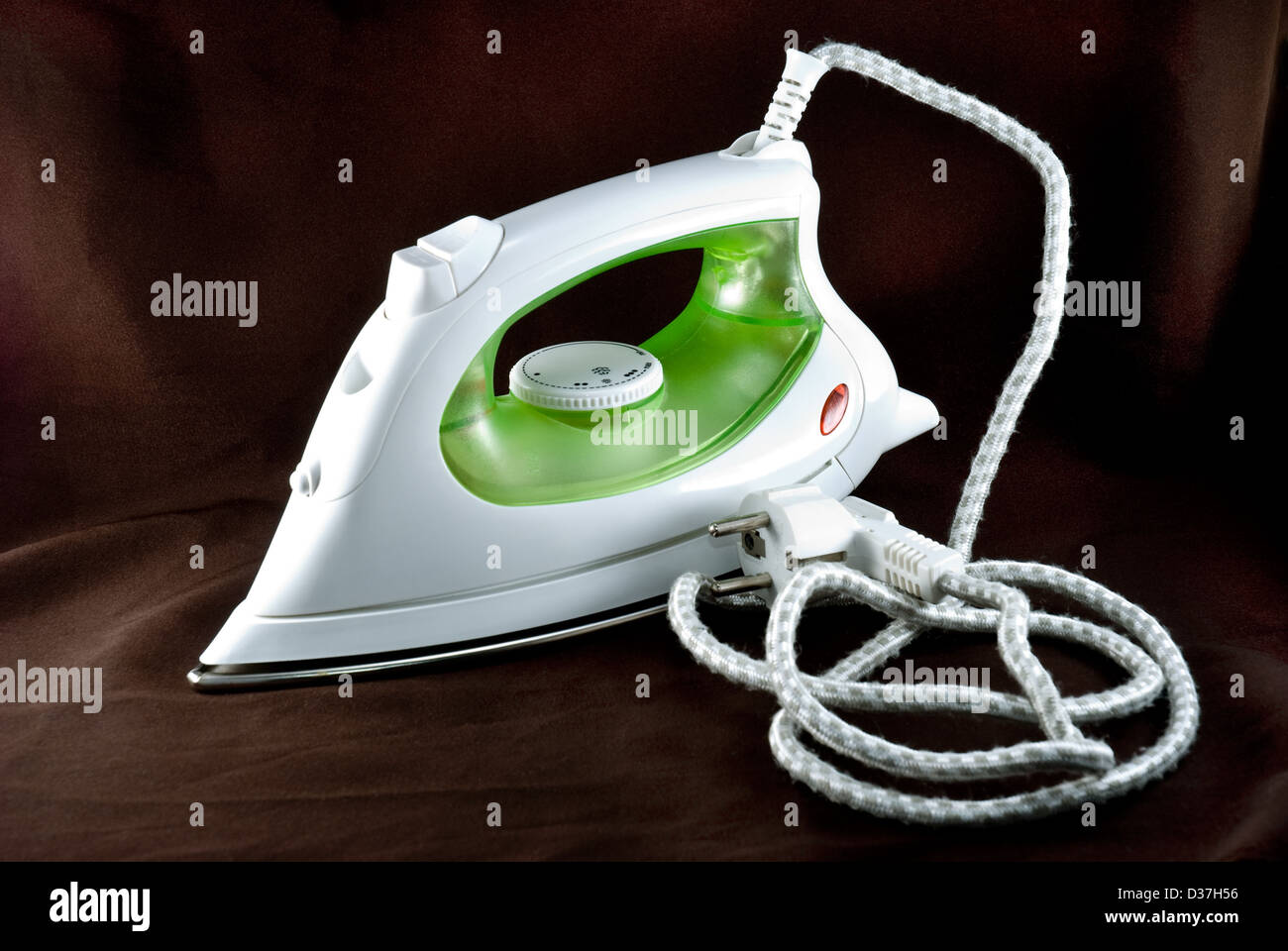 The electric iron stands on a brown background Stock Photo Alamy