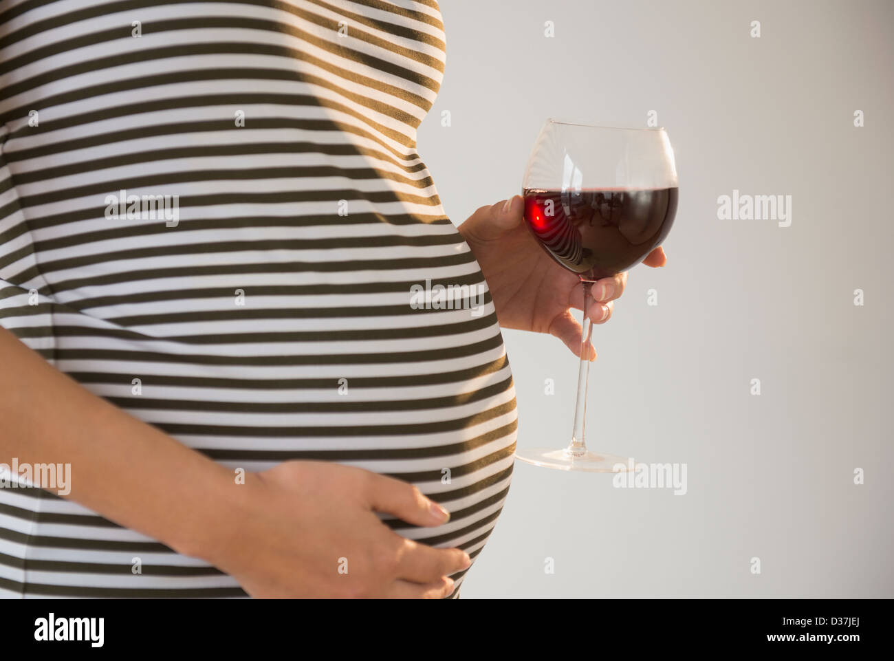 Pregnant woman holding glass of red wine Stock Photo Alamy