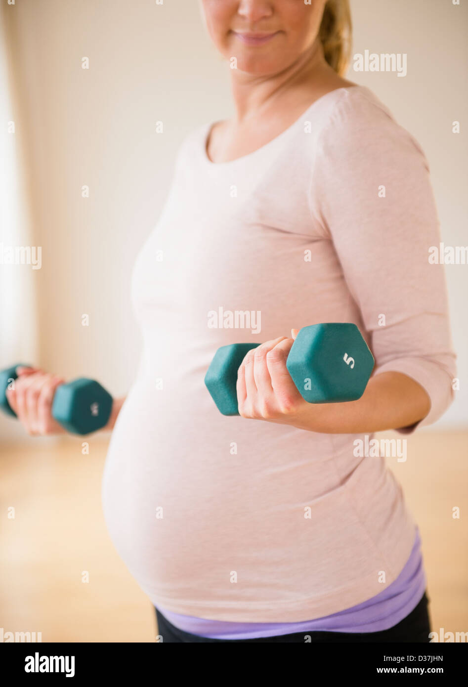 Image showcasing Pregnant woman exercising with dumbbell Stock Photo - Alamy