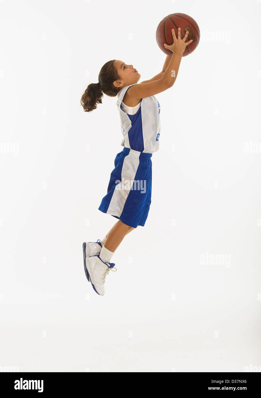 Side view of girl (8-9 years) playing basketball Stock Photo