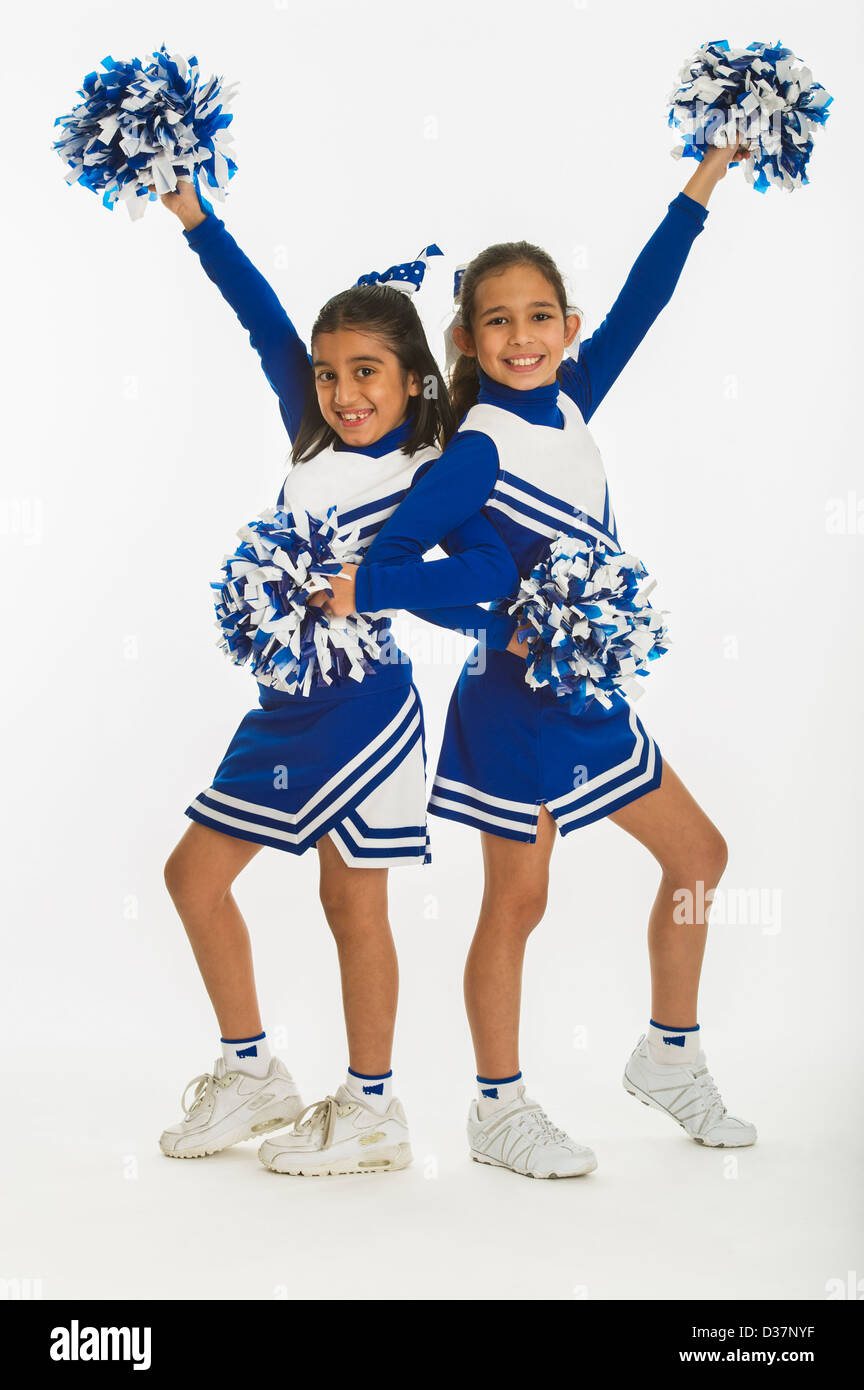 Portrait of cheerleaders (8-9 years) ( 10-11 years) holding pom-pom
